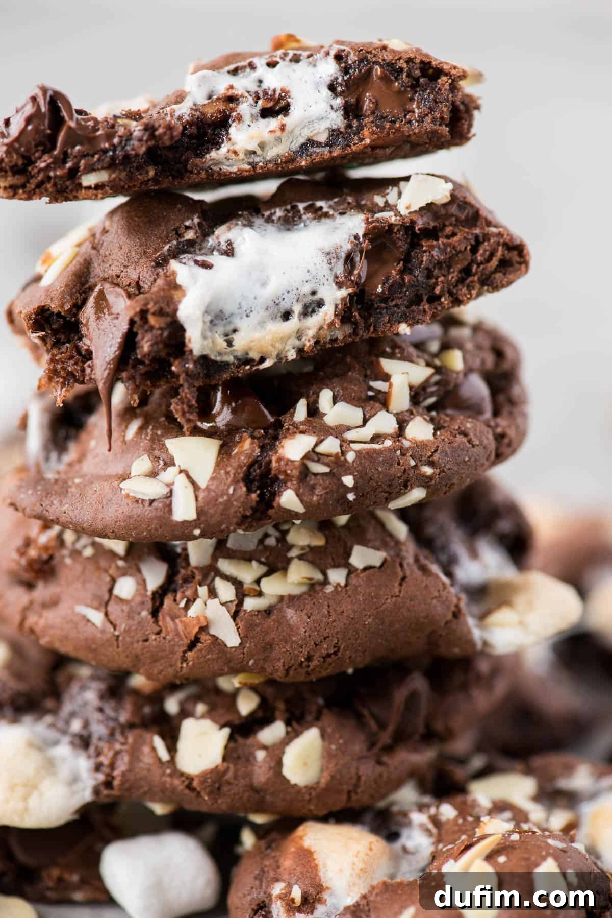 Soft and chewy rocky road cookies will hit the spot and remind you of your favorite rocky road ice cream. These chocolate cookies are packed with almonds, chocolate chips and marshmallows! You don’t have to chill the dough, this rocky road cookie recipe is ready in 30 minutes! Stacked soft and chewy rocky road cookies, showcasing melted marshmallows, chocolate chips, and chopped almonds. Perfect for dessert lovers.