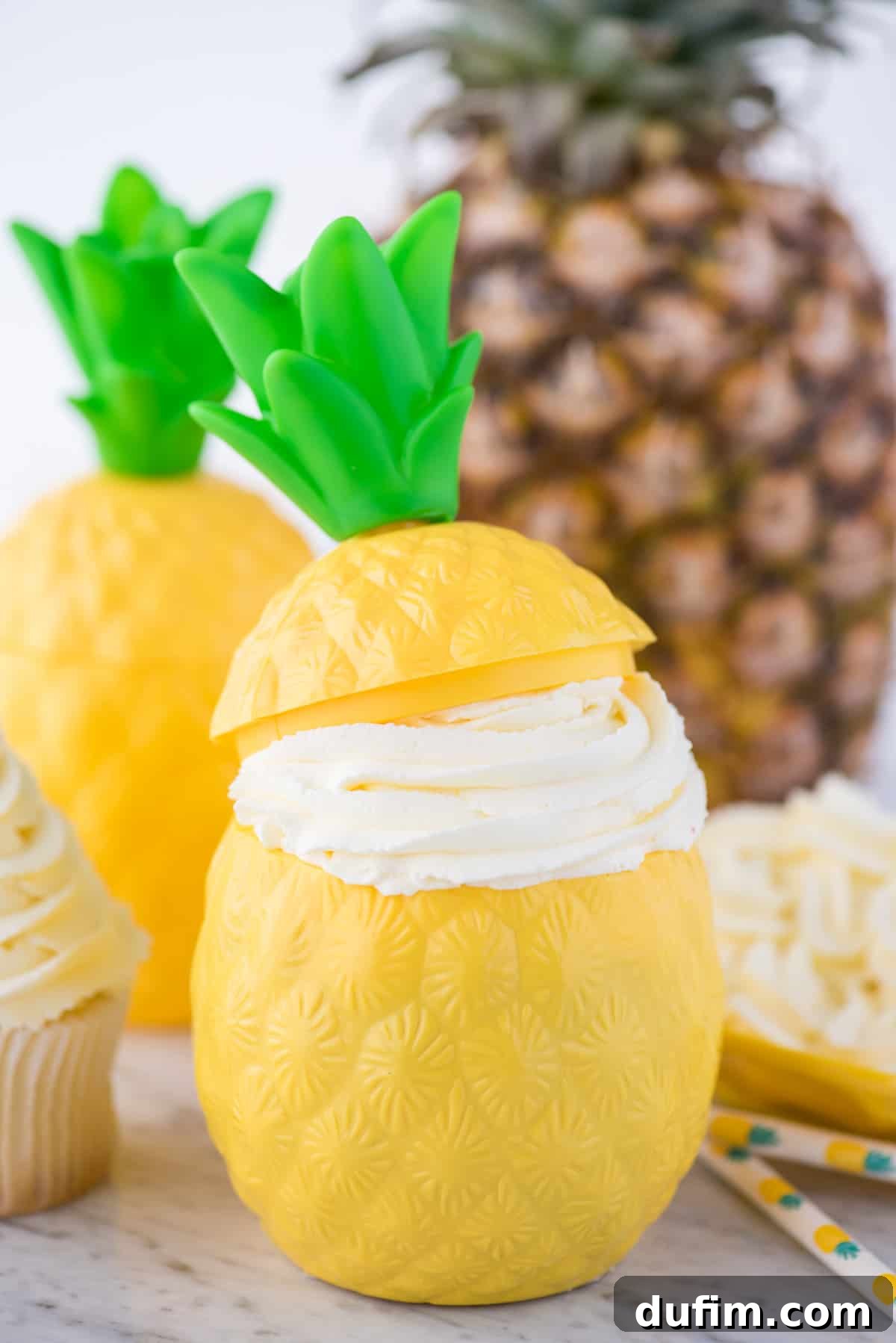 A refreshing pineapple whipped cream dessert generously served in a whimsical plastic pineapple-shaped cup, highlighting its light, airy texture and festive appeal. This vibrant presentation is perfect for summer gatherings and themed parties.