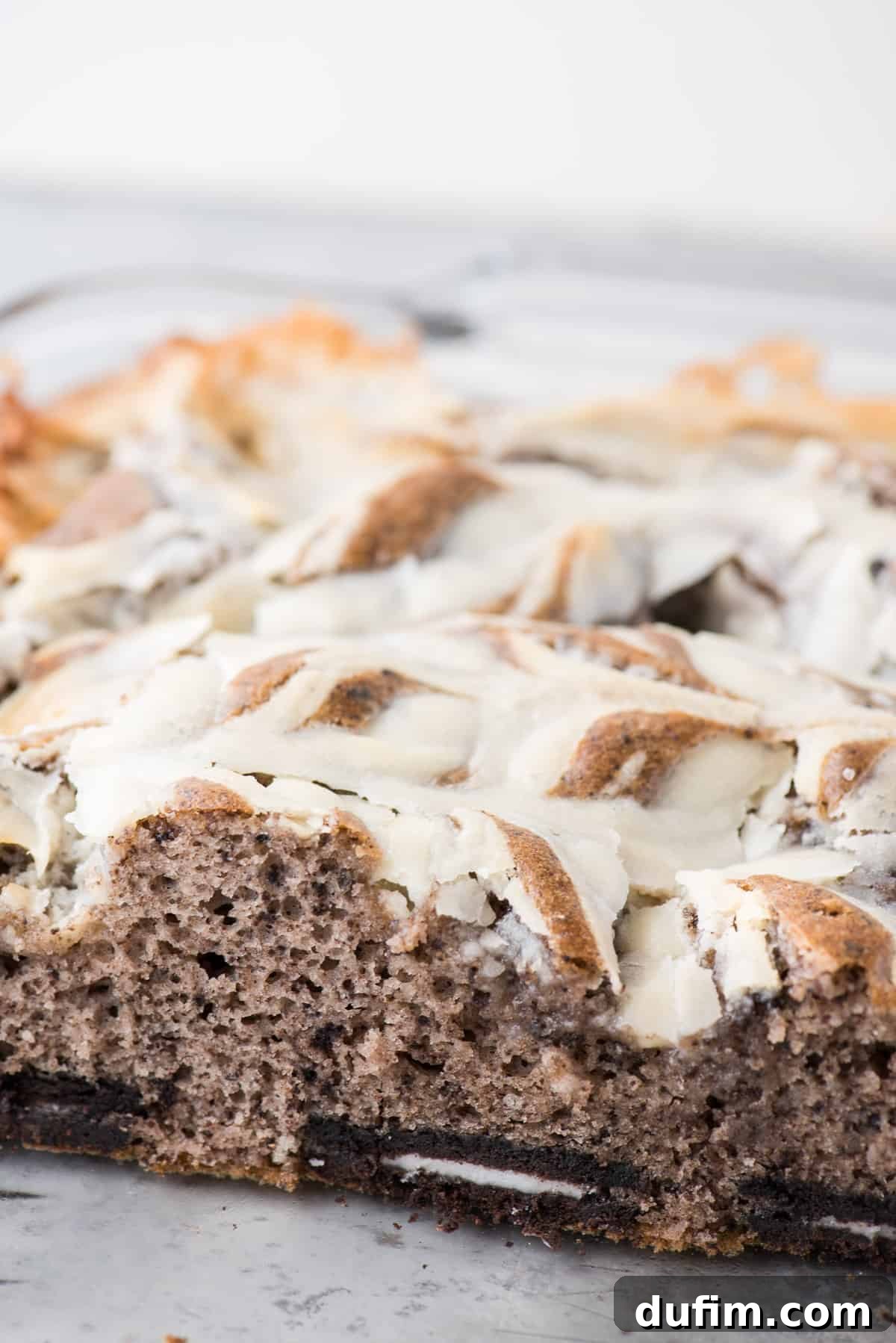 A side view of the baked Oreo Earthquake Cake in its glass pan, highlighting the depth and texture of the cake and its unique frosting layer.