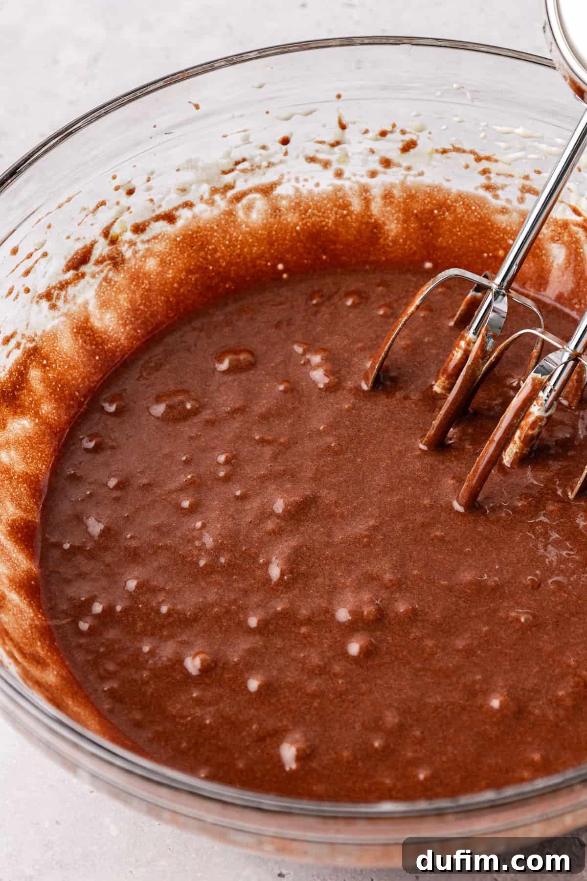 Decadent Chocolate Brownies 13 Close-up of the combined wet ingredients for brownies: chocolate, butter, sugar, eggs, oil, and vanilla, forming a smooth, rich batter.