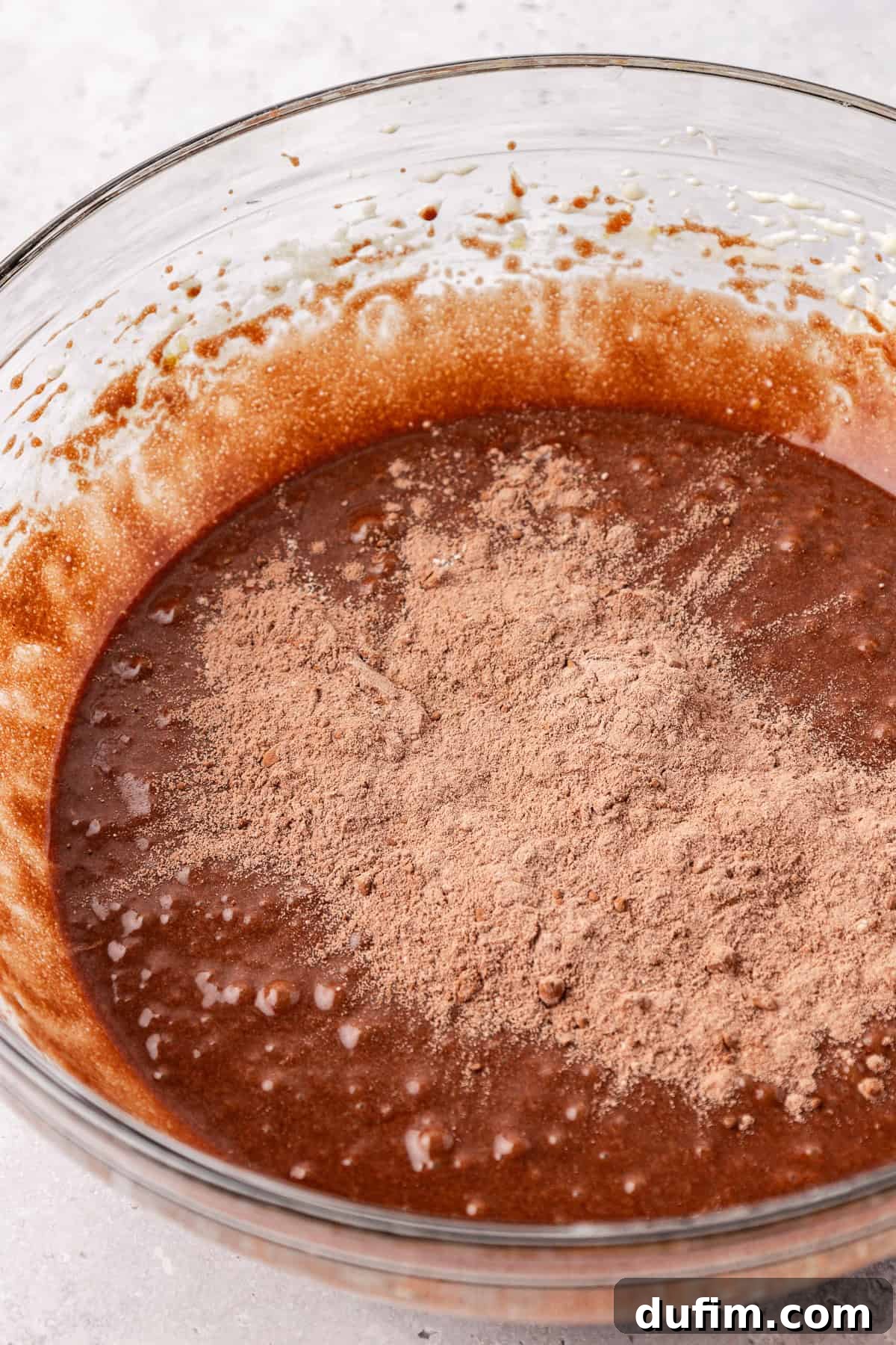 Decadent Chocolate Brownies 14 Step 6: Gradually adding the dry ingredients to the wet brownie mixture in a stand mixer, with a spatula ready to scrape down the sides.