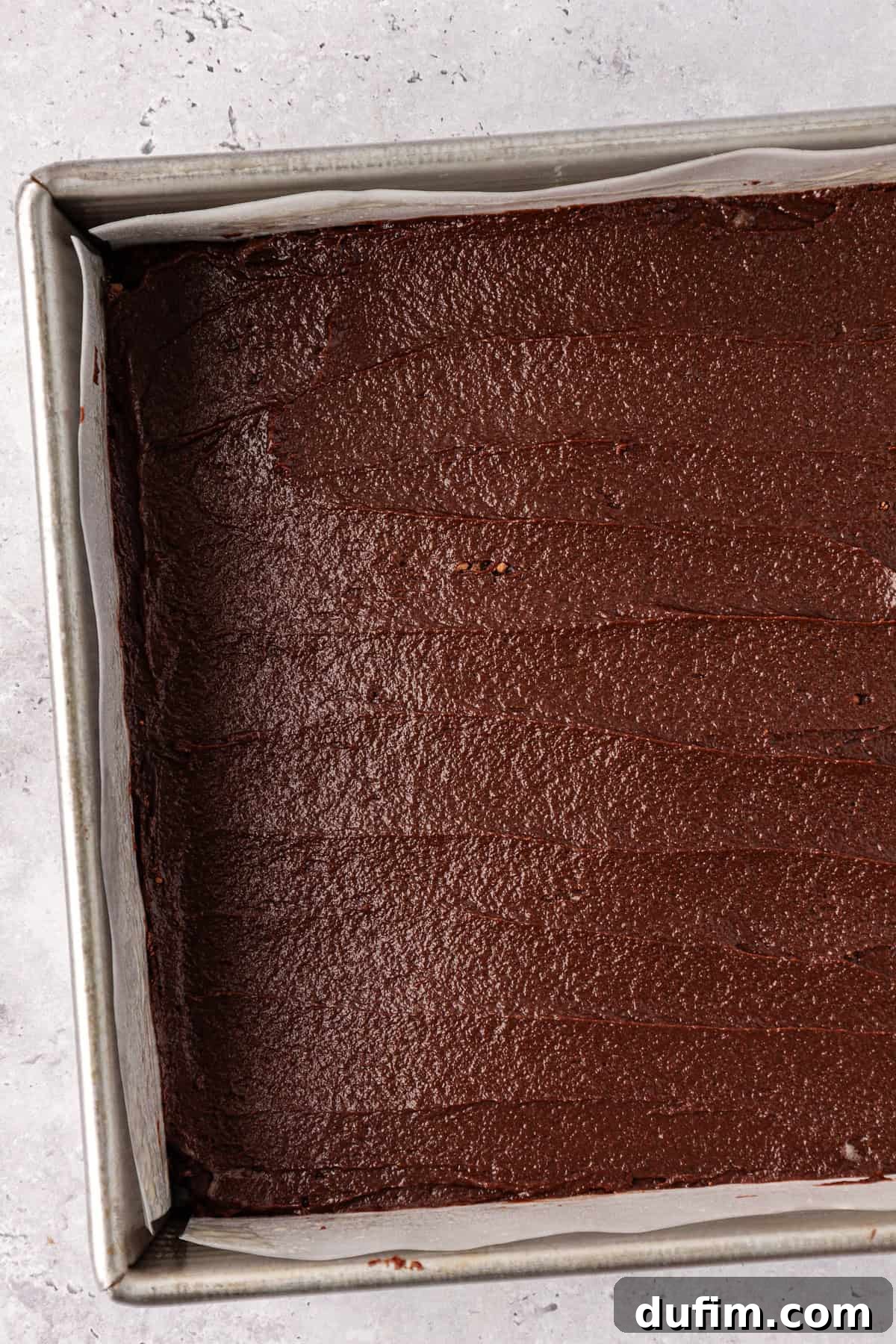 Decadent Chocolate Brownies 16 Step 7: The rich brownie batter poured into a parchment-lined 8x8 inch baking pan, smoothed out and ready for the oven.