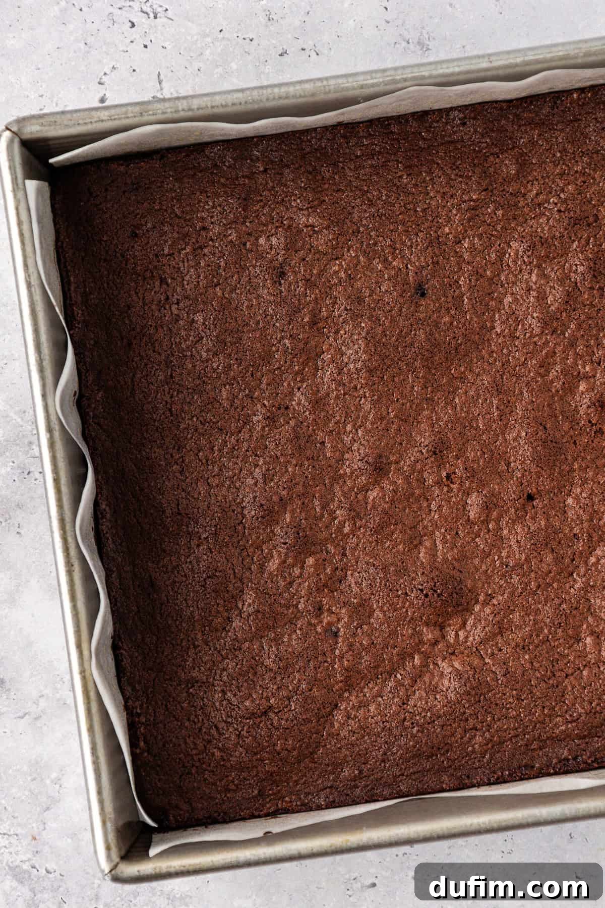 Decadent Chocolate Brownies 17 Freshly baked homemade brownies cooling in their 8x8 inch pan, displaying their beautiful shiny, crackly crust and dense texture.