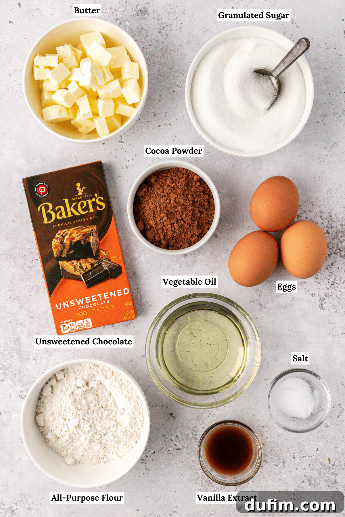 Decadent Chocolate Brownies 4 Essential ingredients for homemade brownies laid out: flour, cocoa powder, unsweetened chocolate, butter, sugar, eggs, vegetable oil, and vanilla extract.