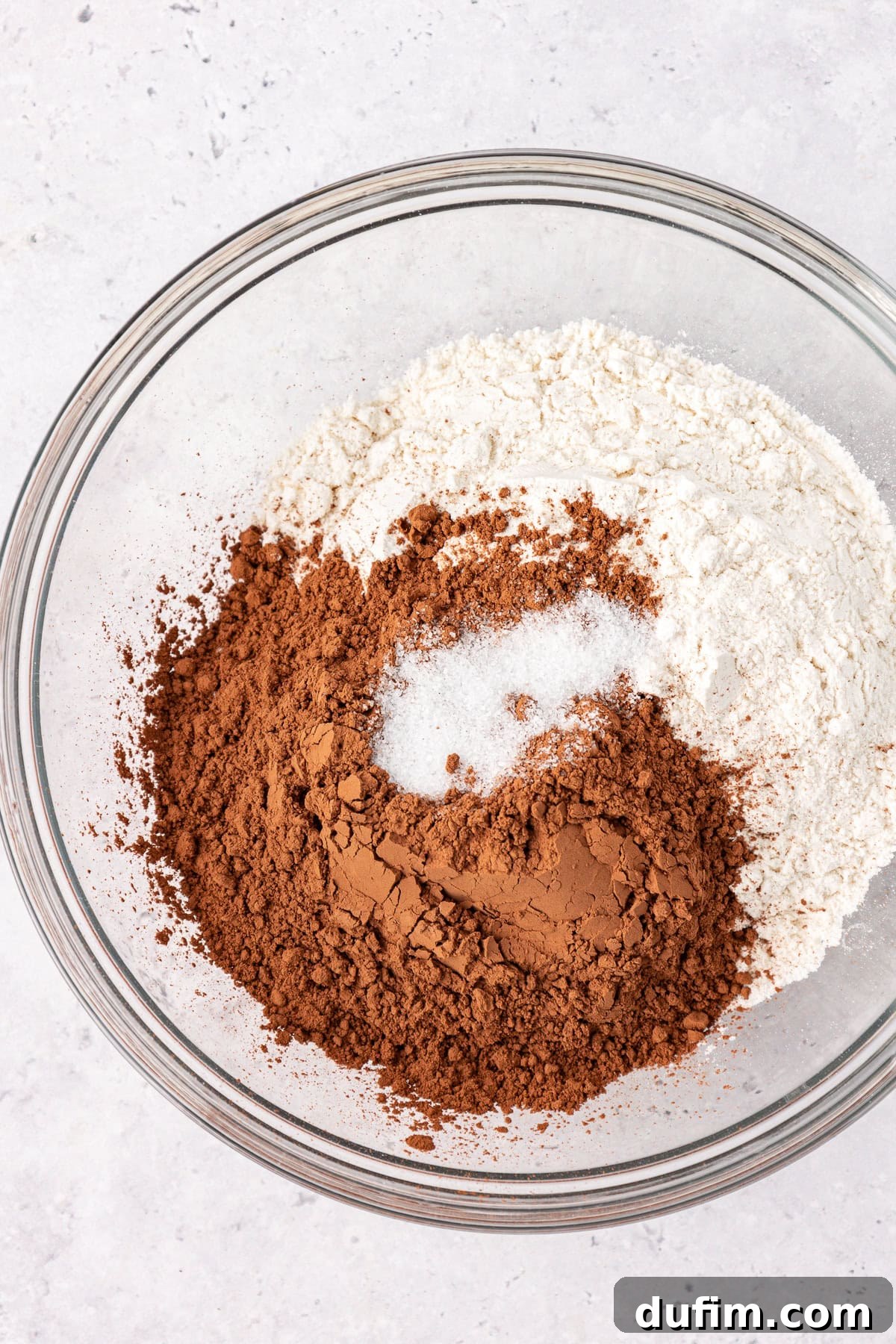 Decadent Chocolate Brownies 6 Step 2: Dry ingredients (flour, salt, cocoa powder) being whisked together in a white bowl.