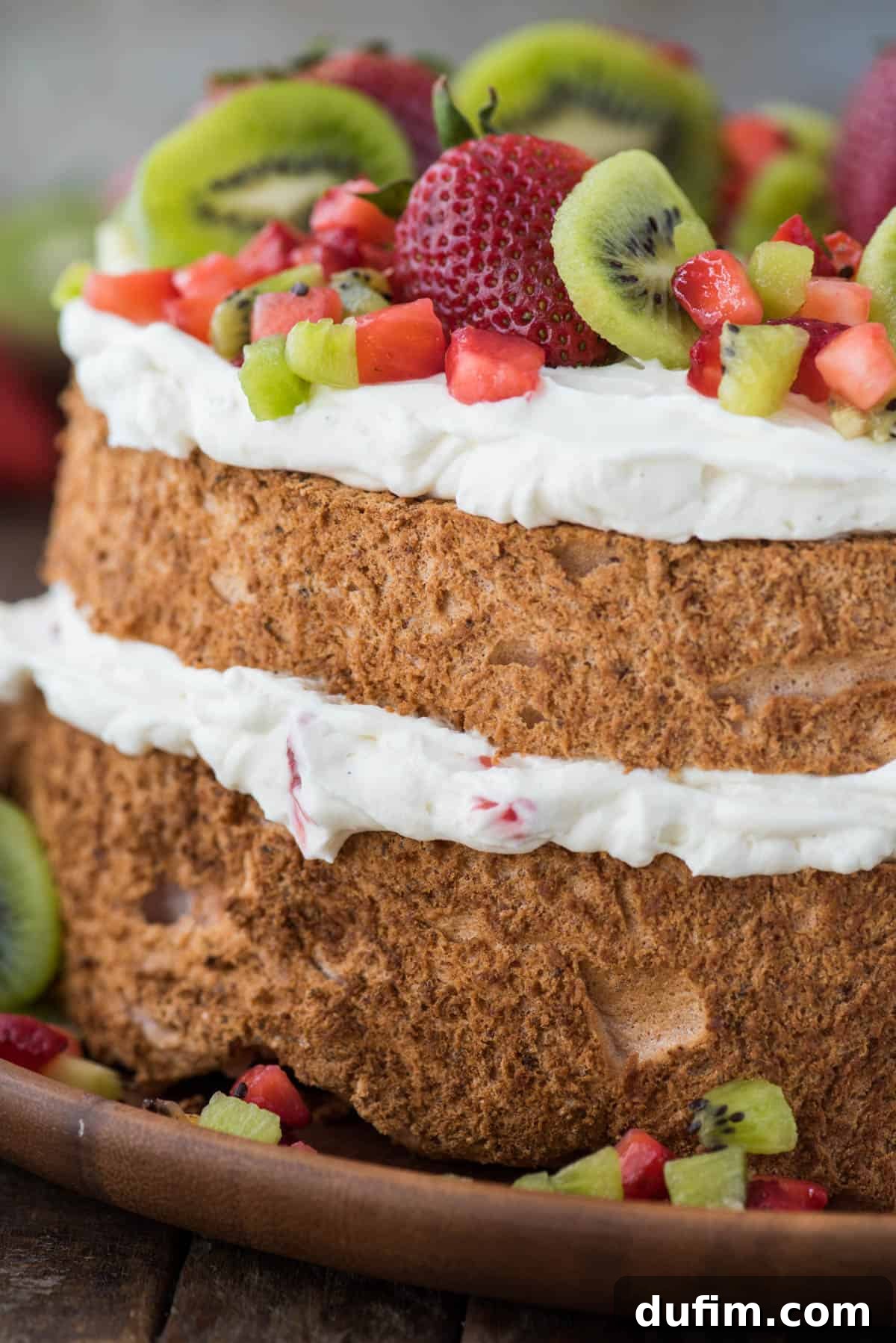 Heavenly Strawberry Cloud Cake 3 close up image of the side of strawberry angel food cake with whipping cream, strawberries and kiwi