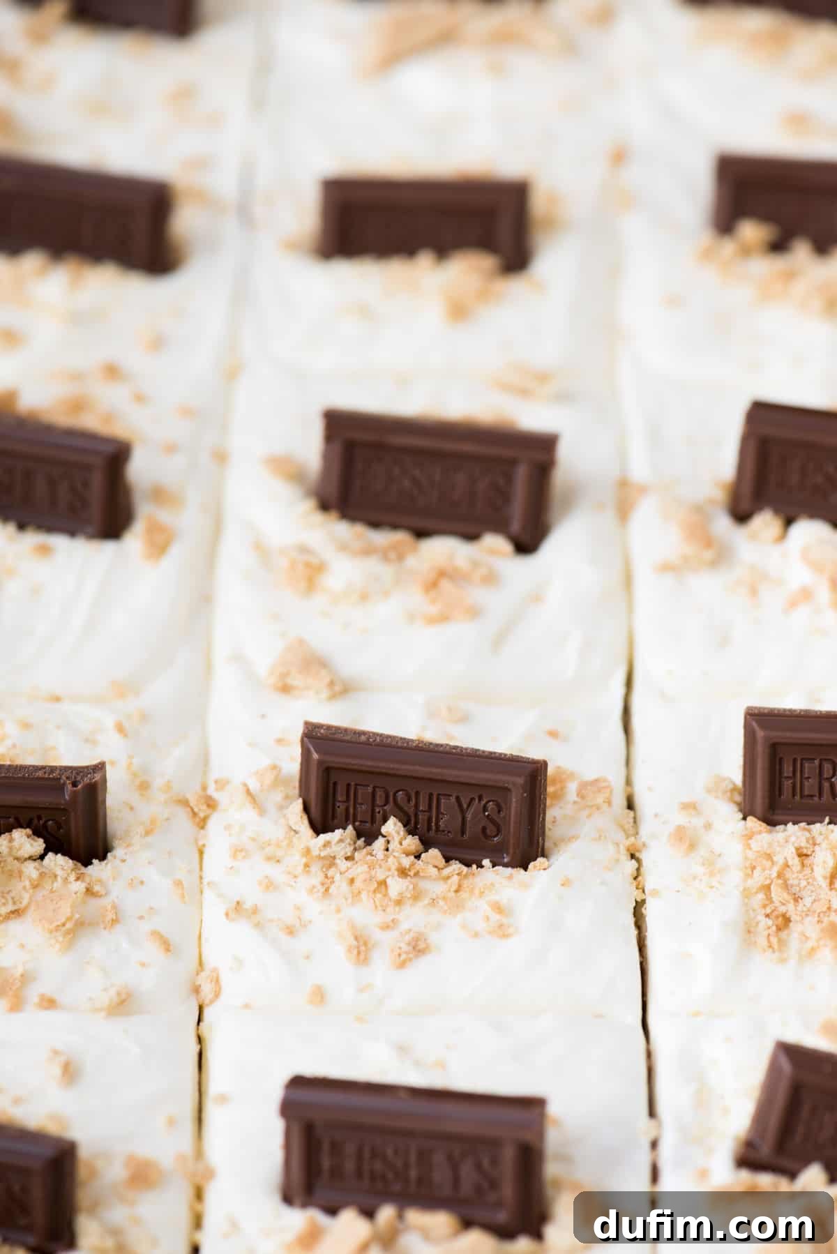 No-Bake S'mores Rice Krispie Treats 3 S’mores bars with fluffy marshmallow frosting and Hershey’s chocolate bar squares arranged in a glass 9x13 inch pan, ready to serve.