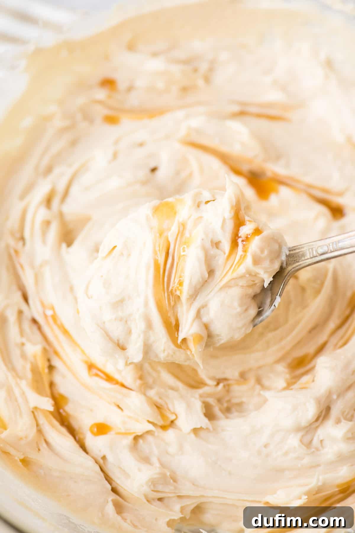 Salted Caramel Buttercream Perfection 2 A spoonful of rich, creamy salted caramel frosting, showcasing its smooth texture and inviting golden hue. Perfect for cakes, cupcakes, and brownies, this homemade buttercream promises delightful indulgence.