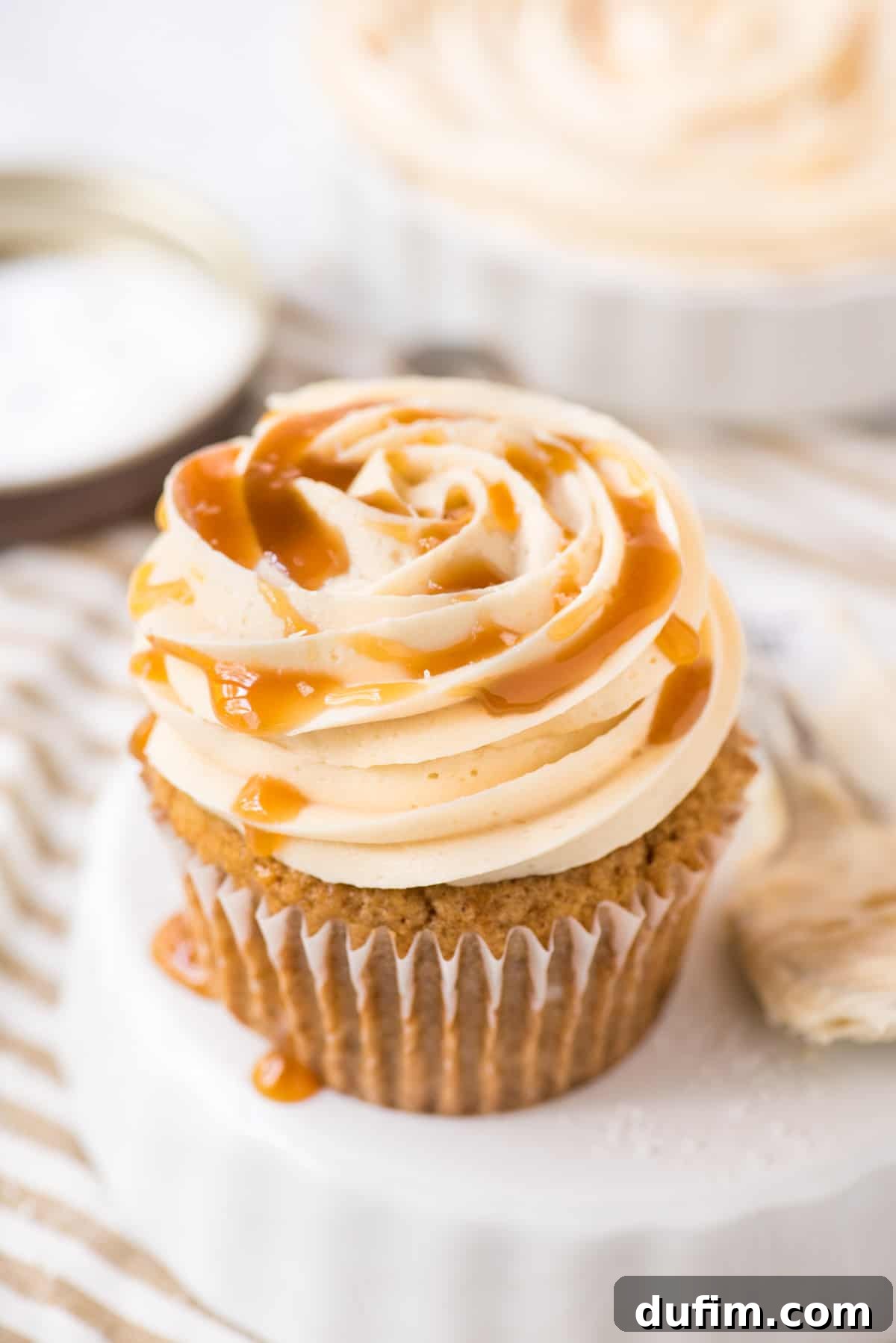 Salted Caramel Buttercream Perfection 3 A perfectly piped cupcake adorned with luscious salted caramel frosting, set against a clean white background. This sweet and salty buttercream is ideal for any celebration.