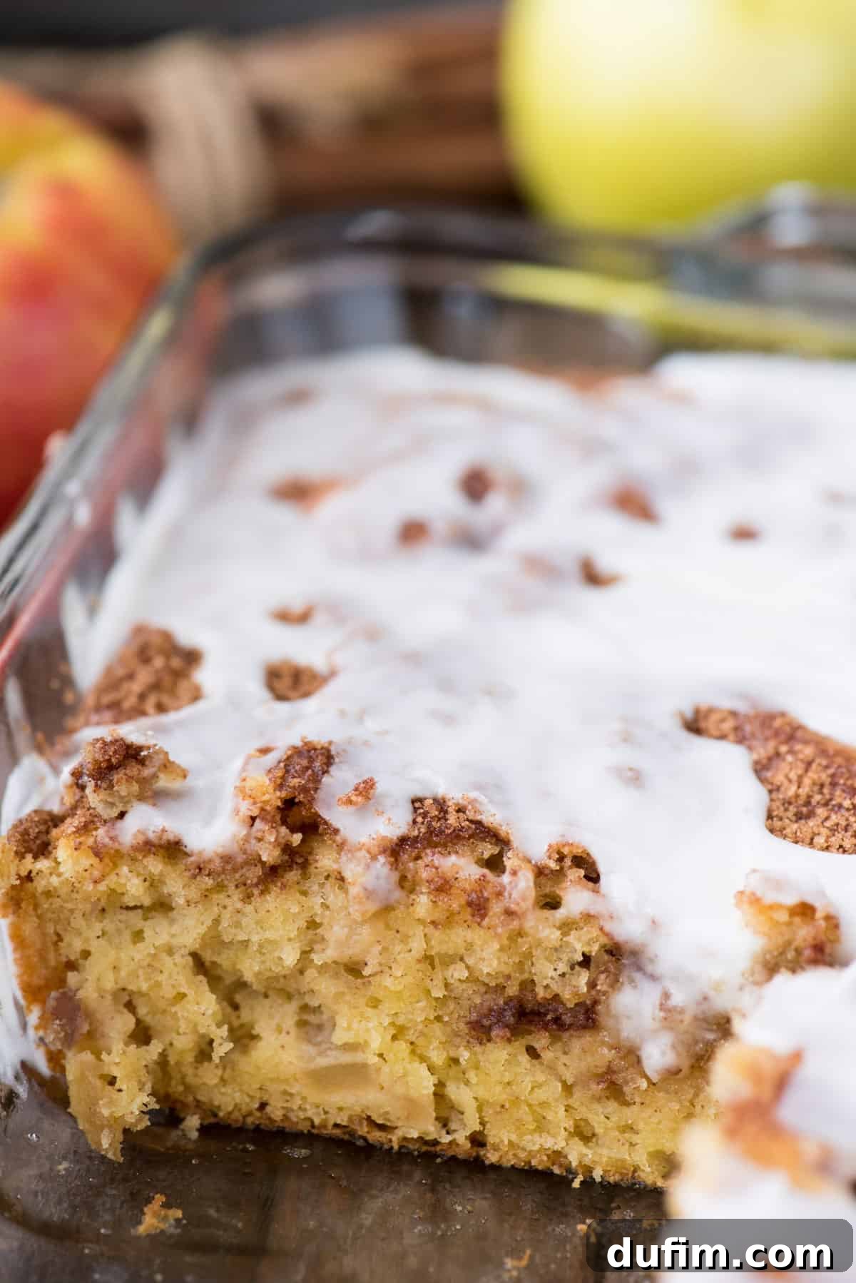 Effortless Apple Spice Coffee Cake 3 Delicious apple coffee cake featuring a rich cinnamon swirl and sweet white icing, baked in a clear glass 9x13 inch pan, ready for serving.