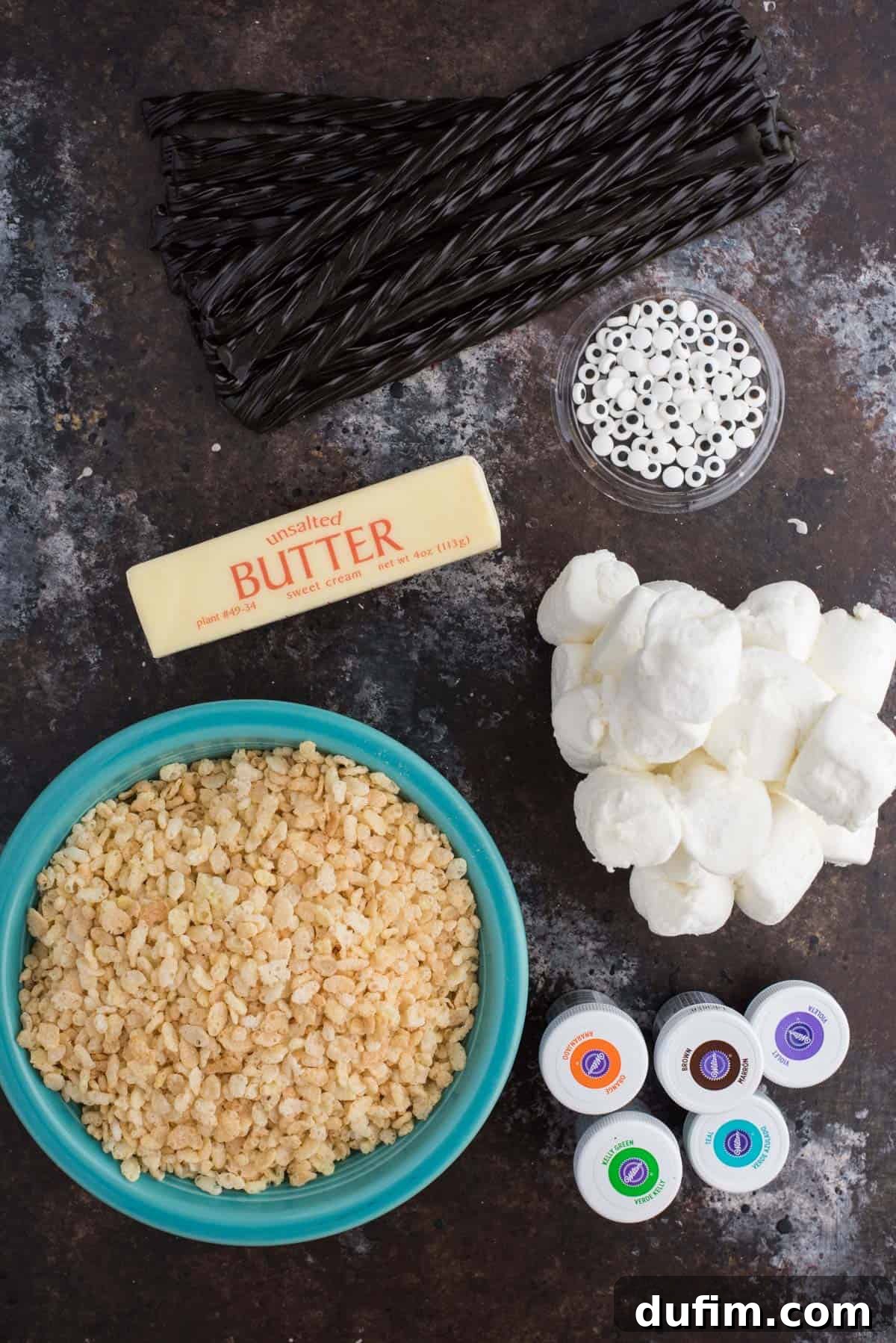 Spooky Spider Rice Krispie Treats 3 A flat lay photograph showcasing all the ingredients needed to craft adorable spider rice krispie treats, including cereal, marshmallows, butter, black licorice, and candy eyeballs.