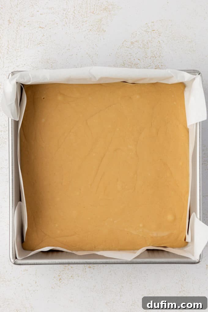 A close-up of set peanut butter fudge in an 8x8 inch metal pan, ready for cutting
