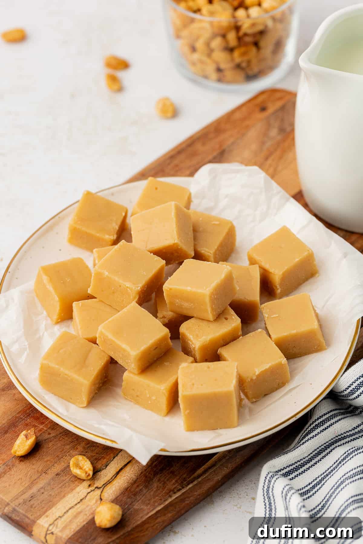 Perfectly cut small pieces of peanut butter fudge artfully displayed on a white plate