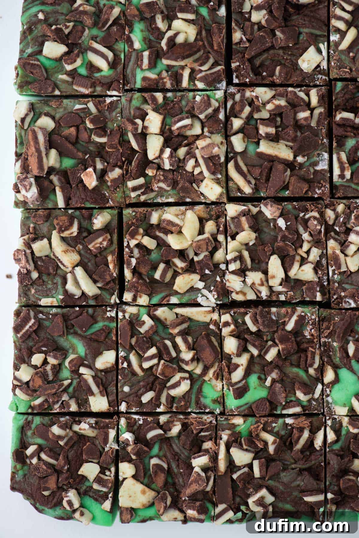 A pristine slab of vibrant mint chocolate fudge, meticulously cut into uniform squares, ready for serving or packaging.