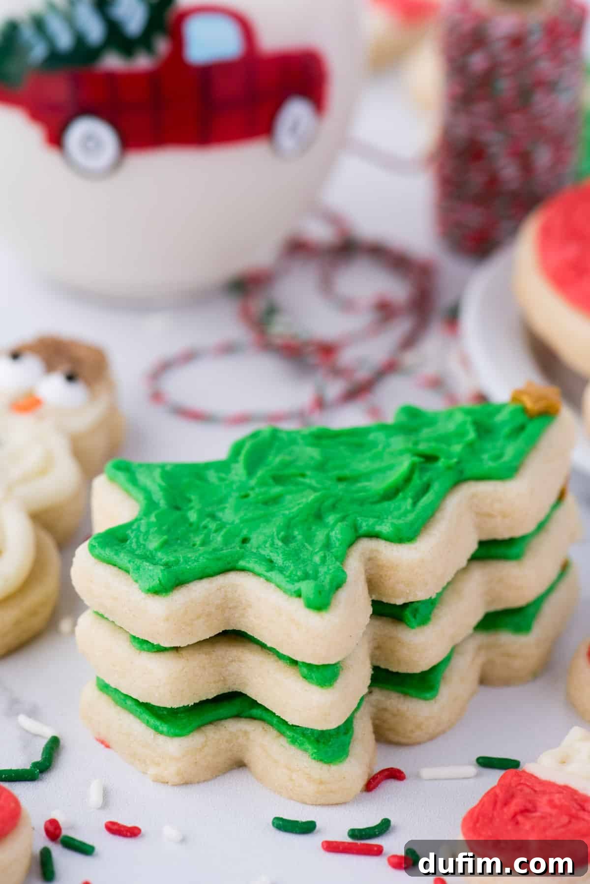 Decorated Christmas tree sugar cookies artfully arranged on a clean white background, demonstrating perfect shape retention achieved through the no-chill method.