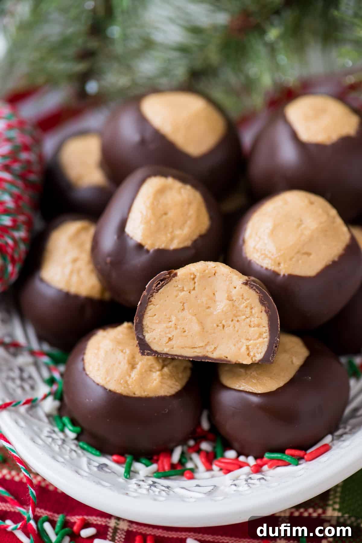 Sweet & Salty Homemade Peanut Butter Buckeye Bites 11 Peanut butter balls beautifully displayed on a white platter, with a red striped towel beneath it.