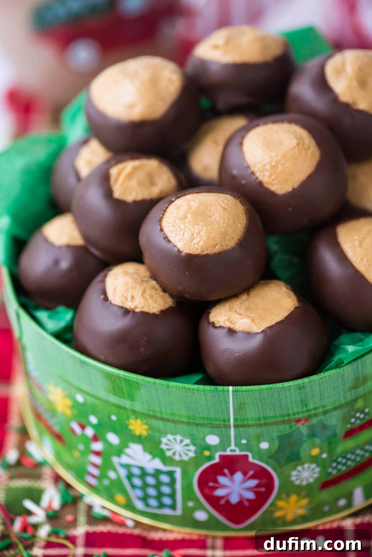 Sweet & Salty Homemade Peanut Butter Buckeye Bites 12 Peanut butter balls presented in a charming green Christmas cookie tin, with a red striped towel underneath.