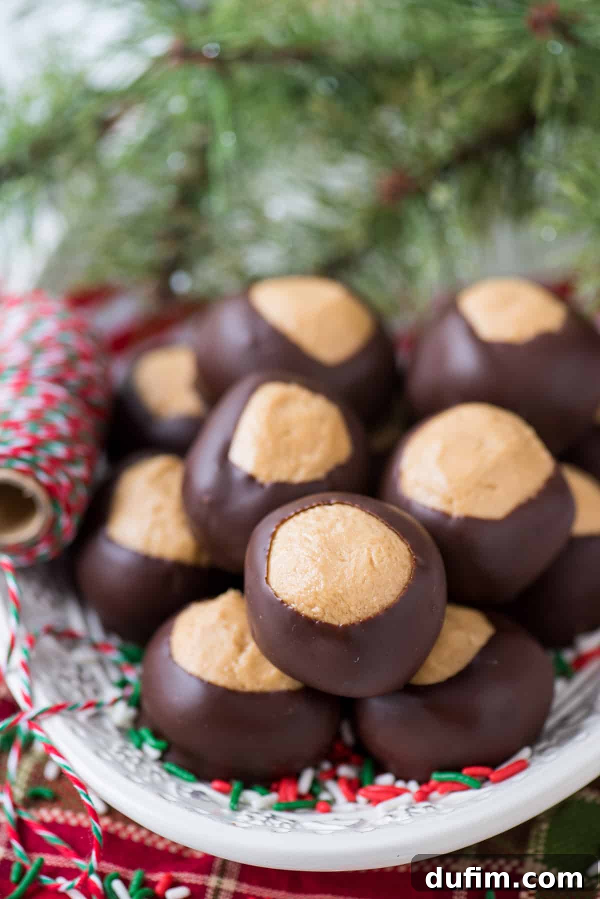 Sweet & Salty Homemade Peanut Butter Buckeye Bites 4 Peanut butter balls artfully arranged on a white platter with a red striped towel nestled beneath the plate.