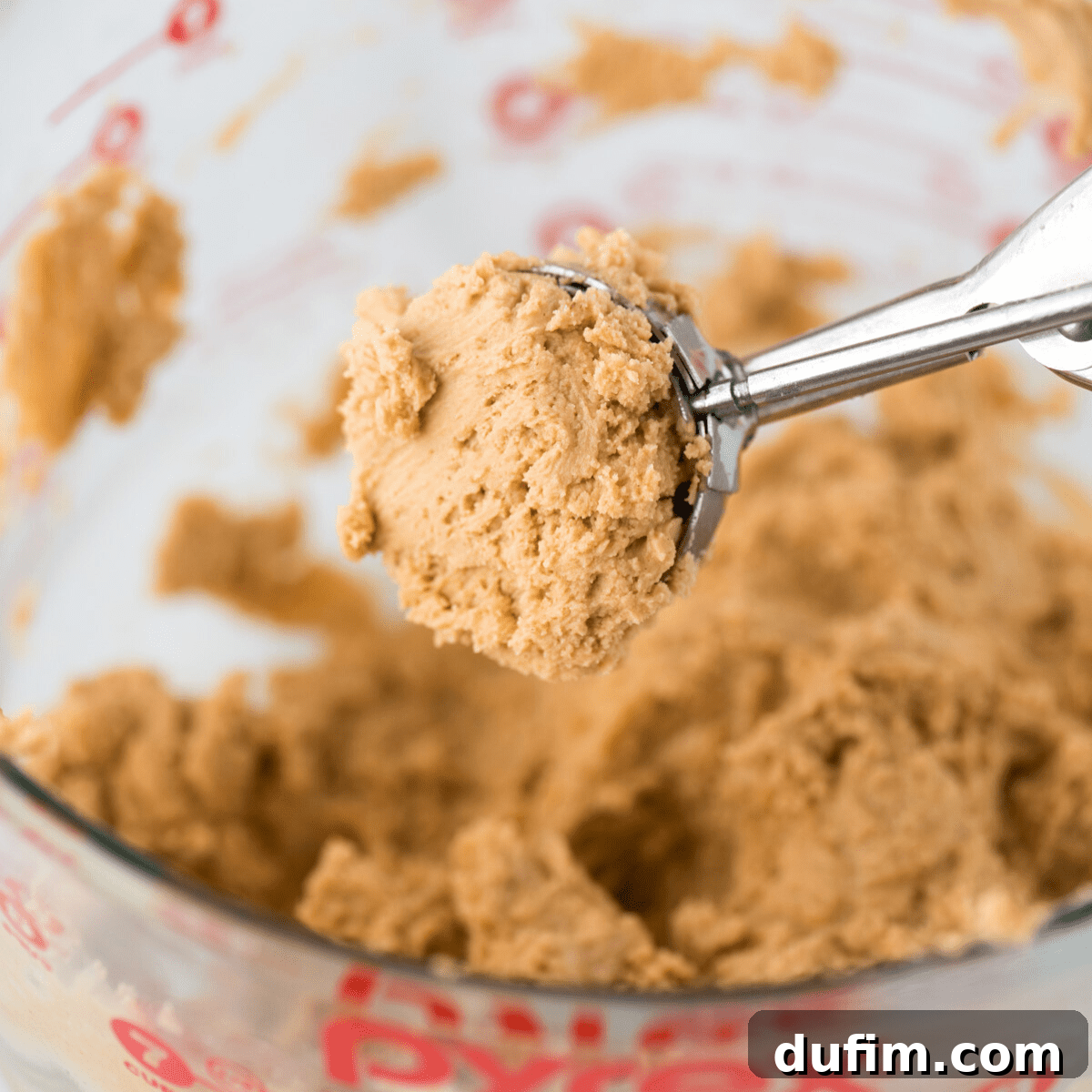 Sweet & Salty Homemade Peanut Butter Buckeye Bites 5 Peanut butter ball mixture precisely scooped into a cookie scoop, ready for rolling.