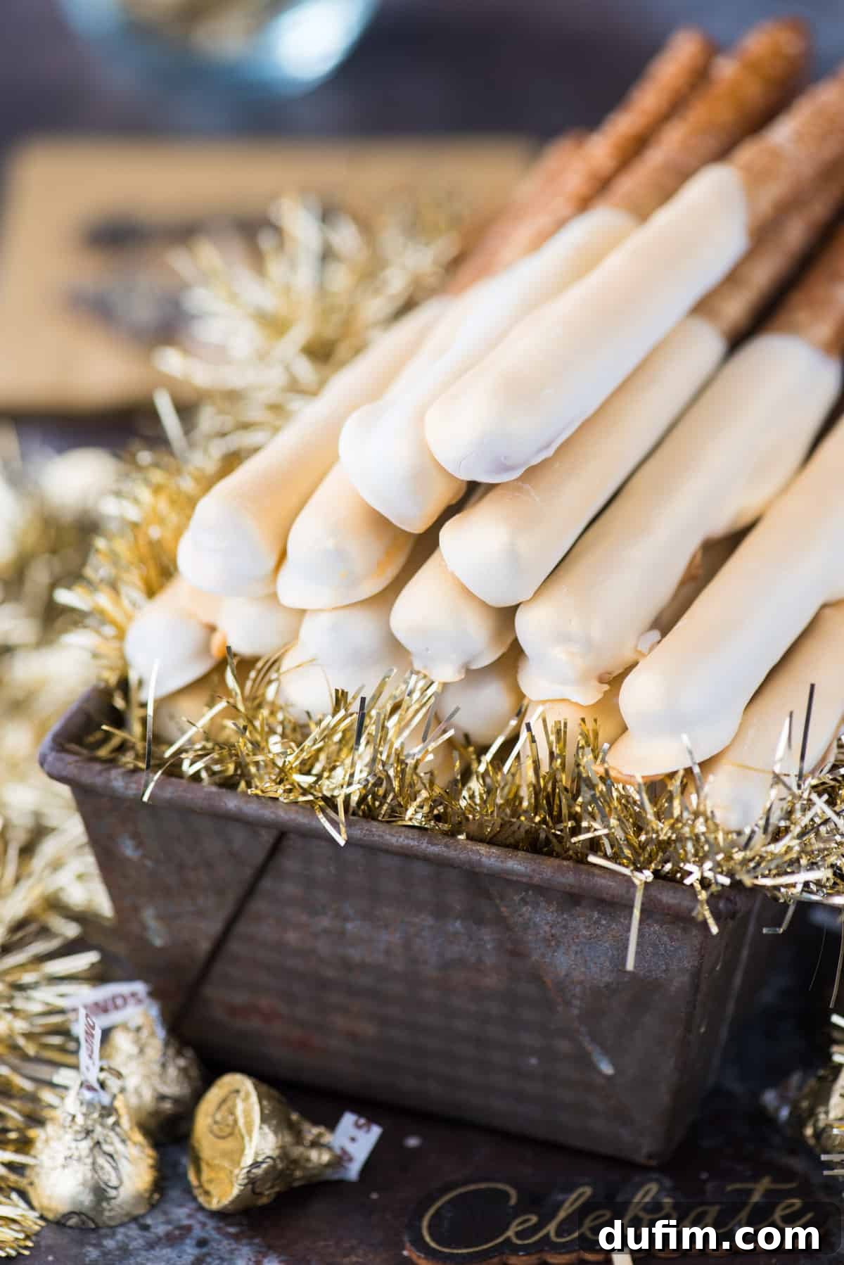 Luxurious New Year's Eve gold pretzel rods, expertly dipped in caramel and white chocolate, adorned with a dazzling edible gold paint, ready for celebration.