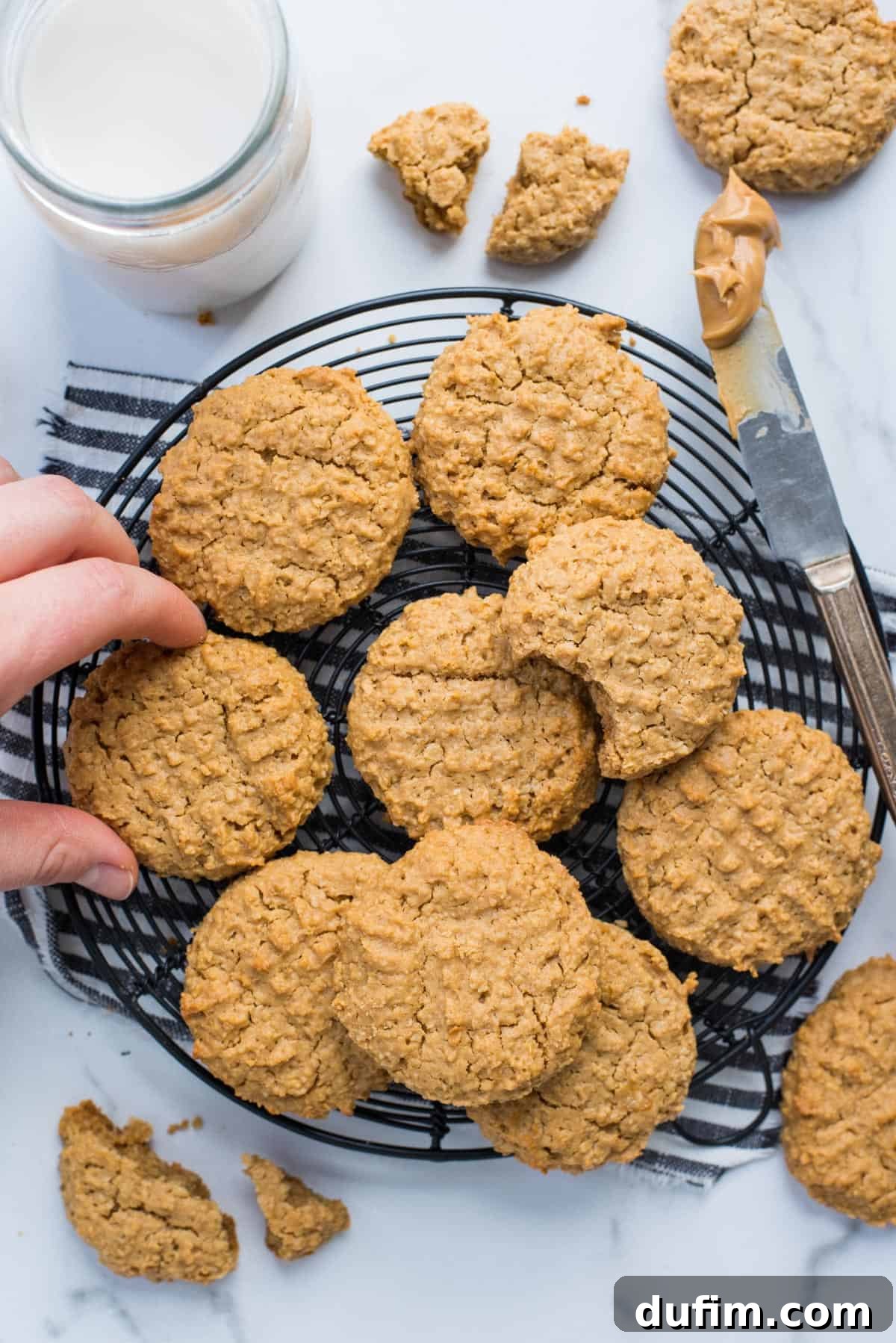 Guilt-Free Peanut Butter Oatmeal Treats 6 Healthy peanut butter cookies cooling on a black wire rack, showcasing their rustic charm and golden-brown edges.