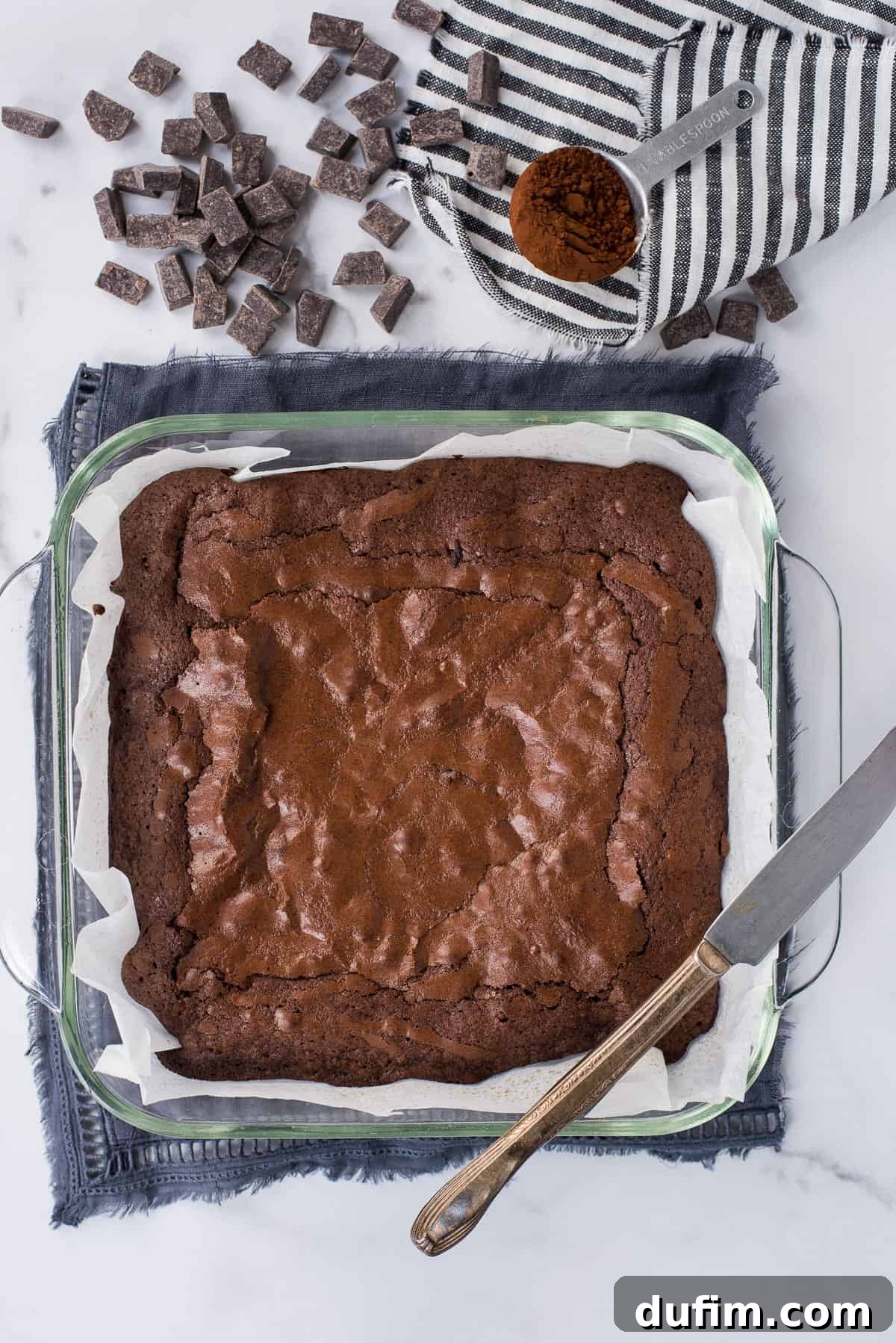 A glass baking pan filled with freshly baked, cooled brownies, neatly cut into squares, ready for serving.
