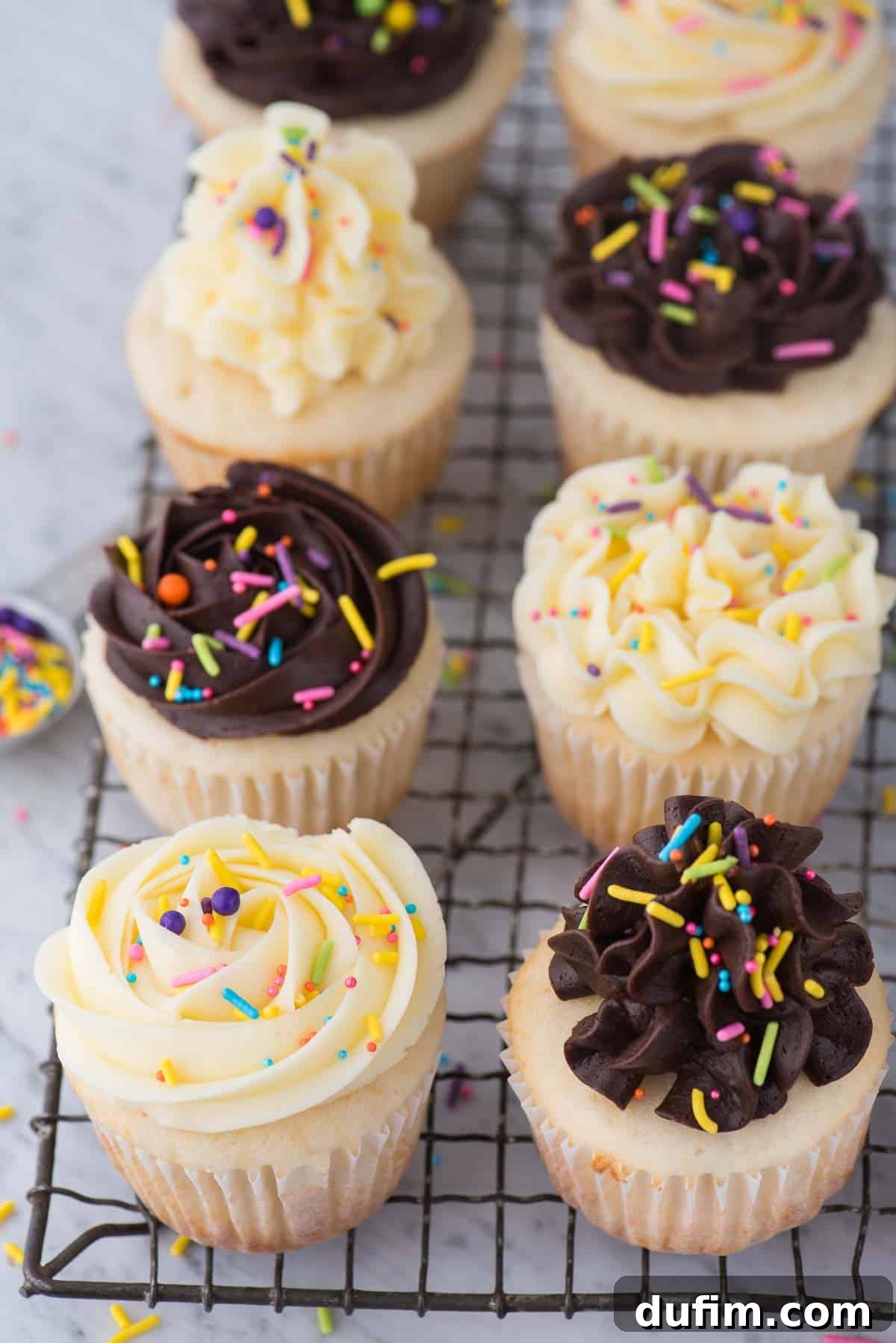 Deliciously Simple White Cupcakes 6 easy white cupcakes with chocolate or vanilla frosting with colorful sprinkles on wire cooling rack
