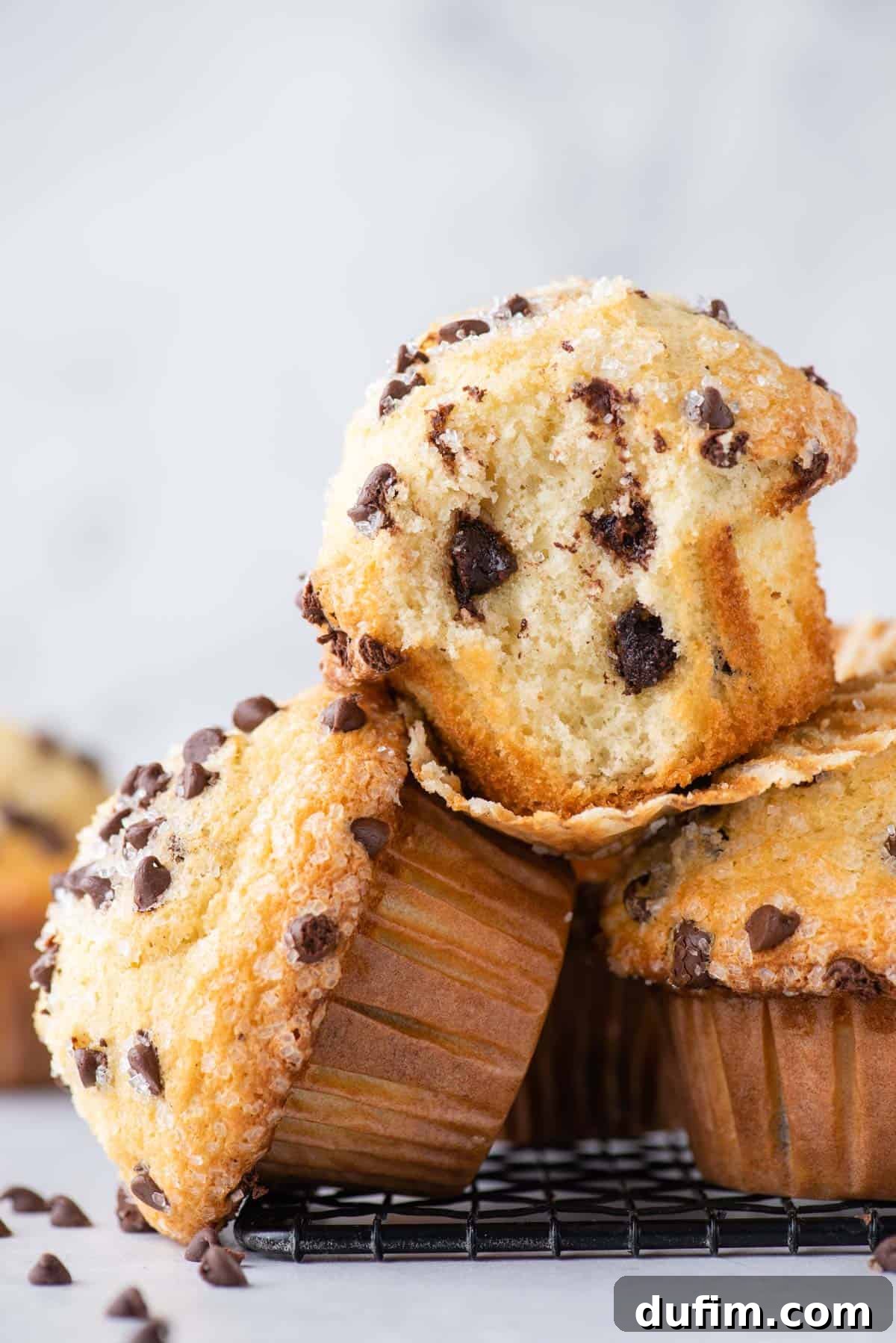 a few chocolate chip muffins stacked on black wire rack