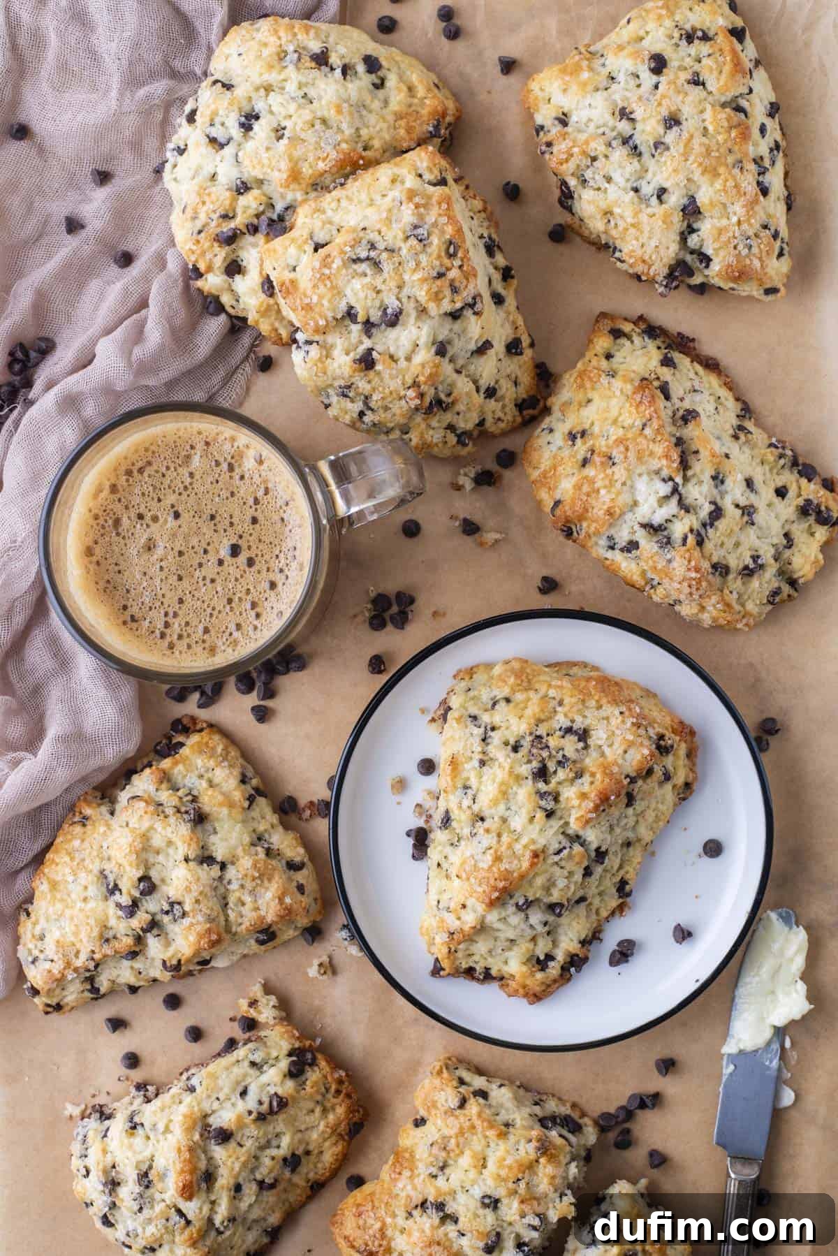 Gourmet Chocolate Chip Buttermilk Scones 2 Freshly baked chocolate chip scones arranged on brown parchment paper, highlighting their golden tops and generous chocolate distribution.