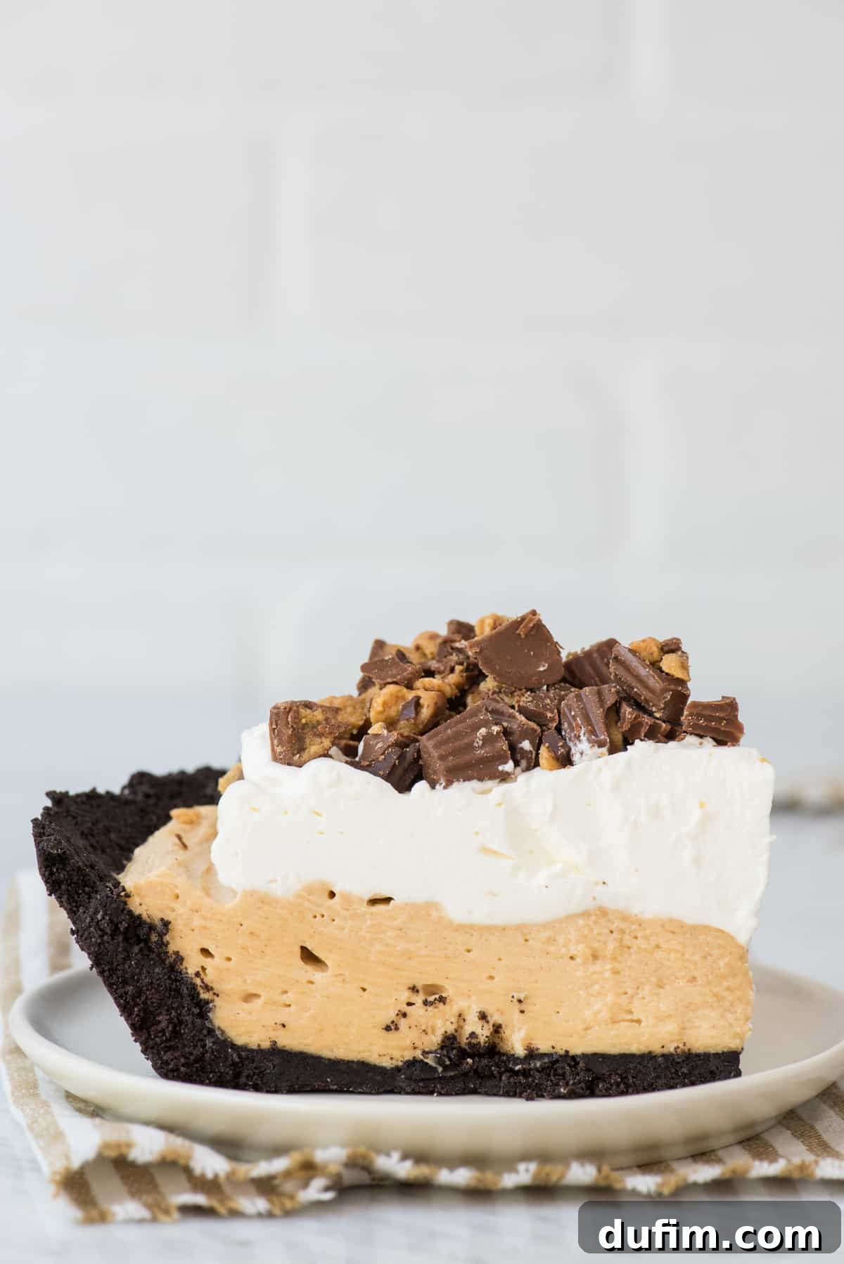slice of peanut butter pie on white plate with white background