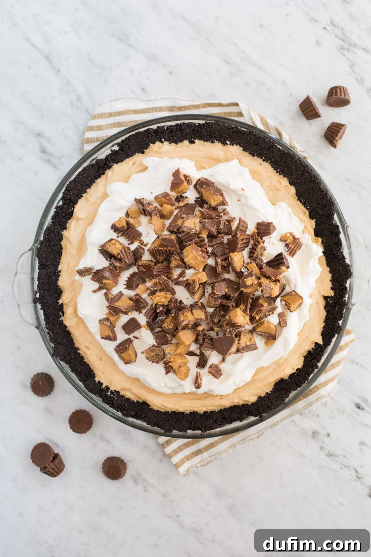 whole peanut butter pie in pie pan on marble background