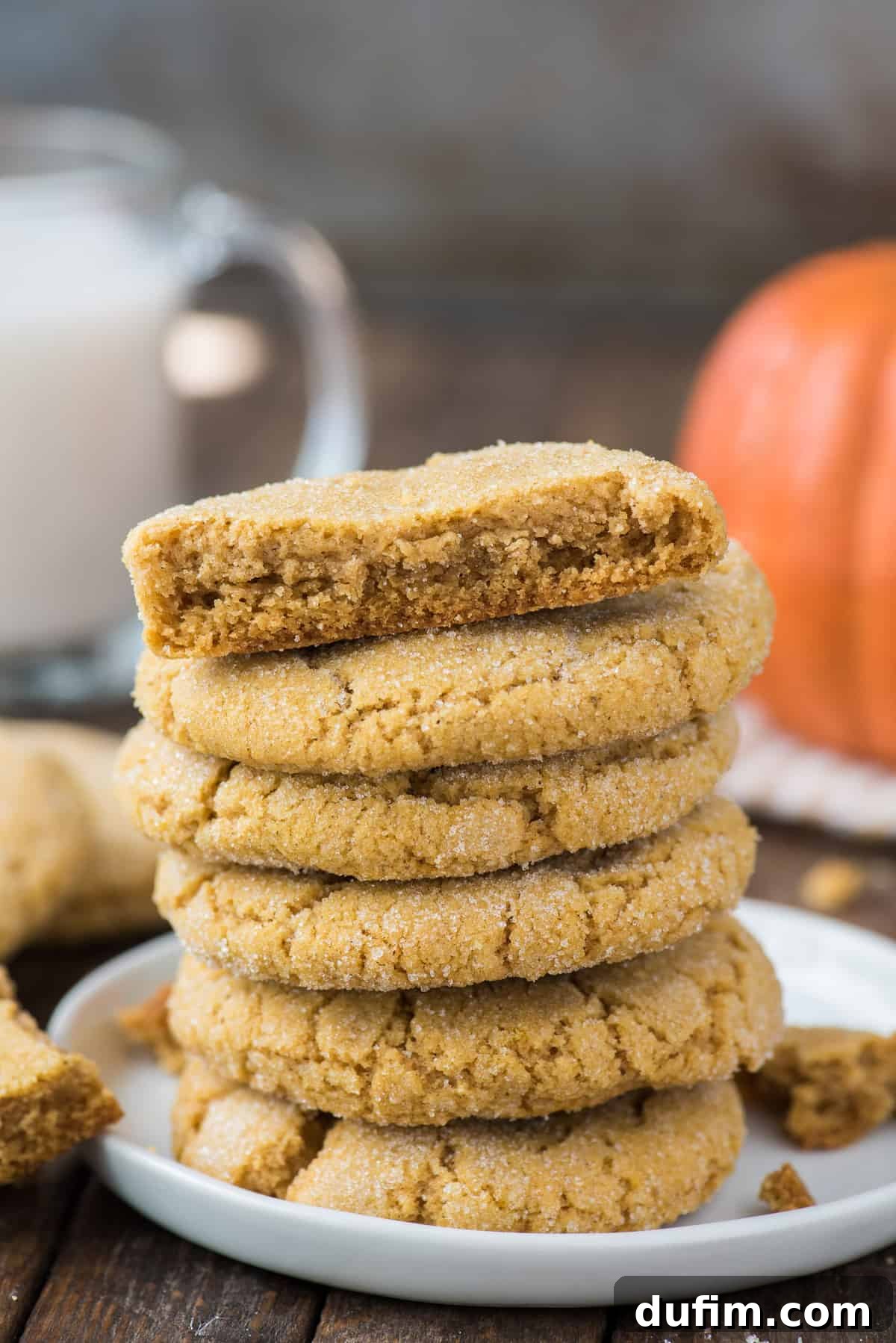 Cozy Pumpkin Cookie Bliss 3 6 pumpkin cookies stacked in a tower on white plate with brown background