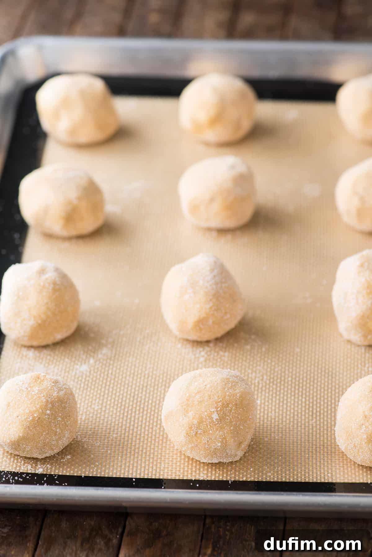 Cozy Pumpkin Cookie Bliss 5 pumpkin cookie dough balls rolled in sugar lined up on a silicone baking mat