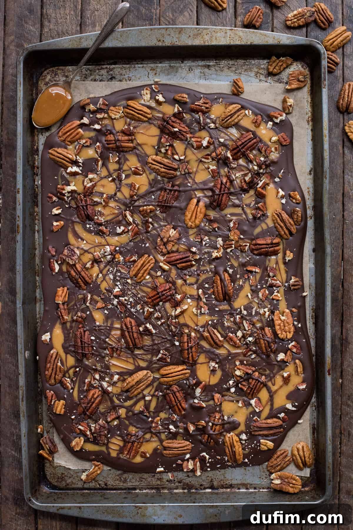 Chocolate caramel pecan turtle bark slab on metal baking sheet