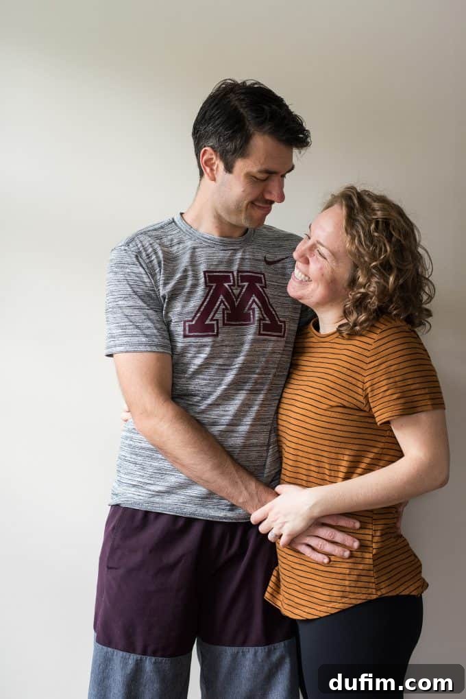Author showing her 12-week baby bump, smiling brightly