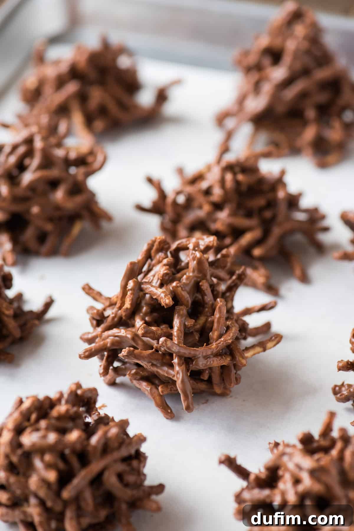 chocolate haystack cookies on white parchment paper