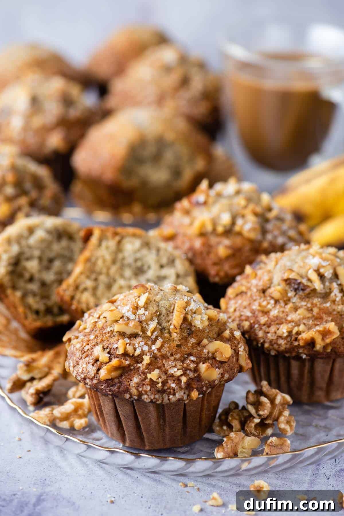banana nut muffins displayed on glass dish on purple background
