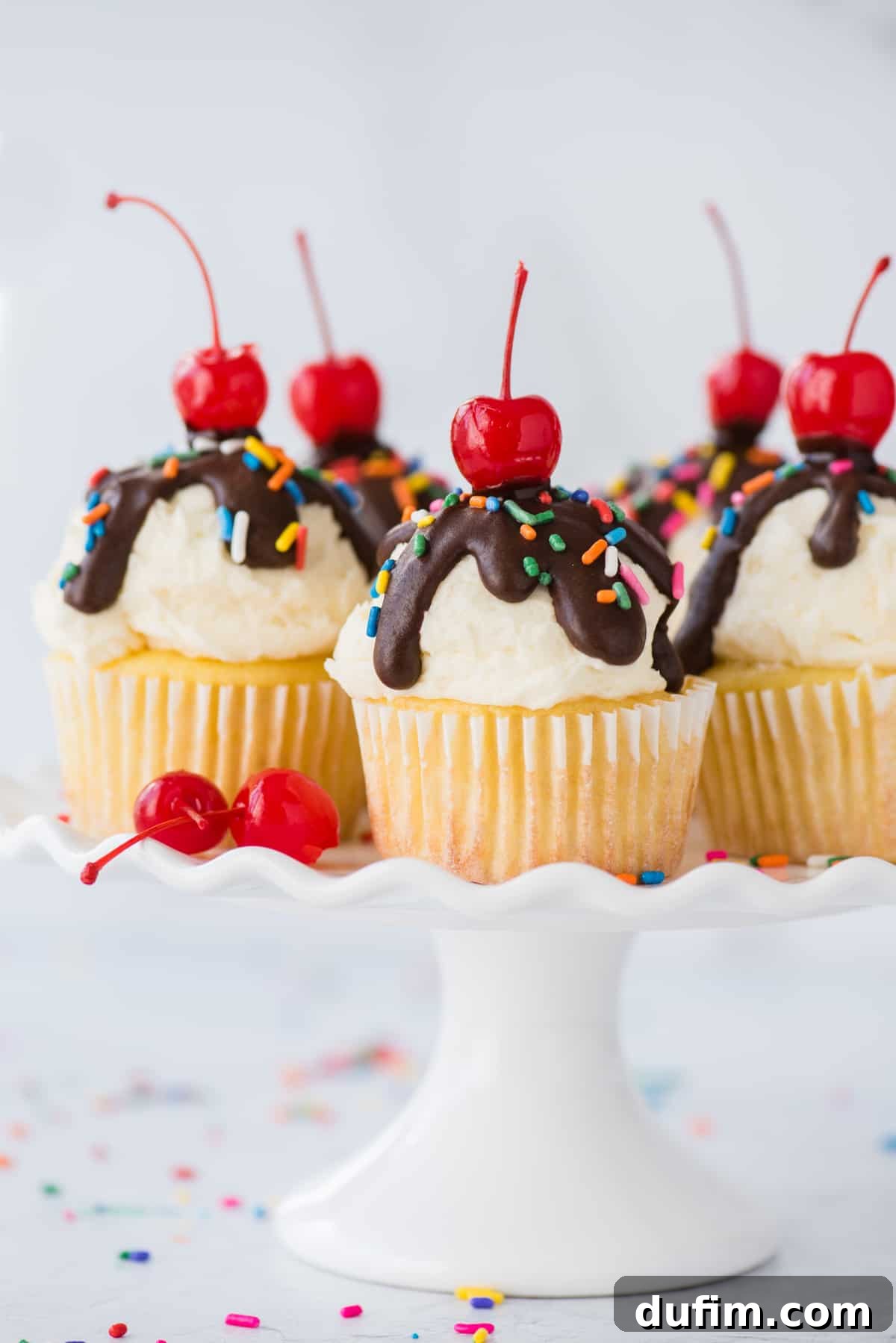 Ice cream cupcakes displayed beautifully on a white cake stand against a pristine white background. Each cupcake is a miniature celebration, promising a delightful fusion of cake and ice cream.