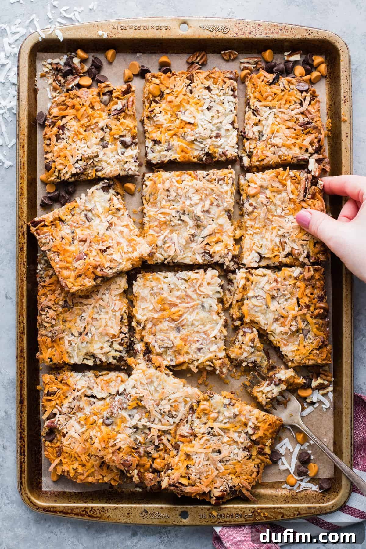hello dolly bars cut into squares and arranged on a metal baking sheet