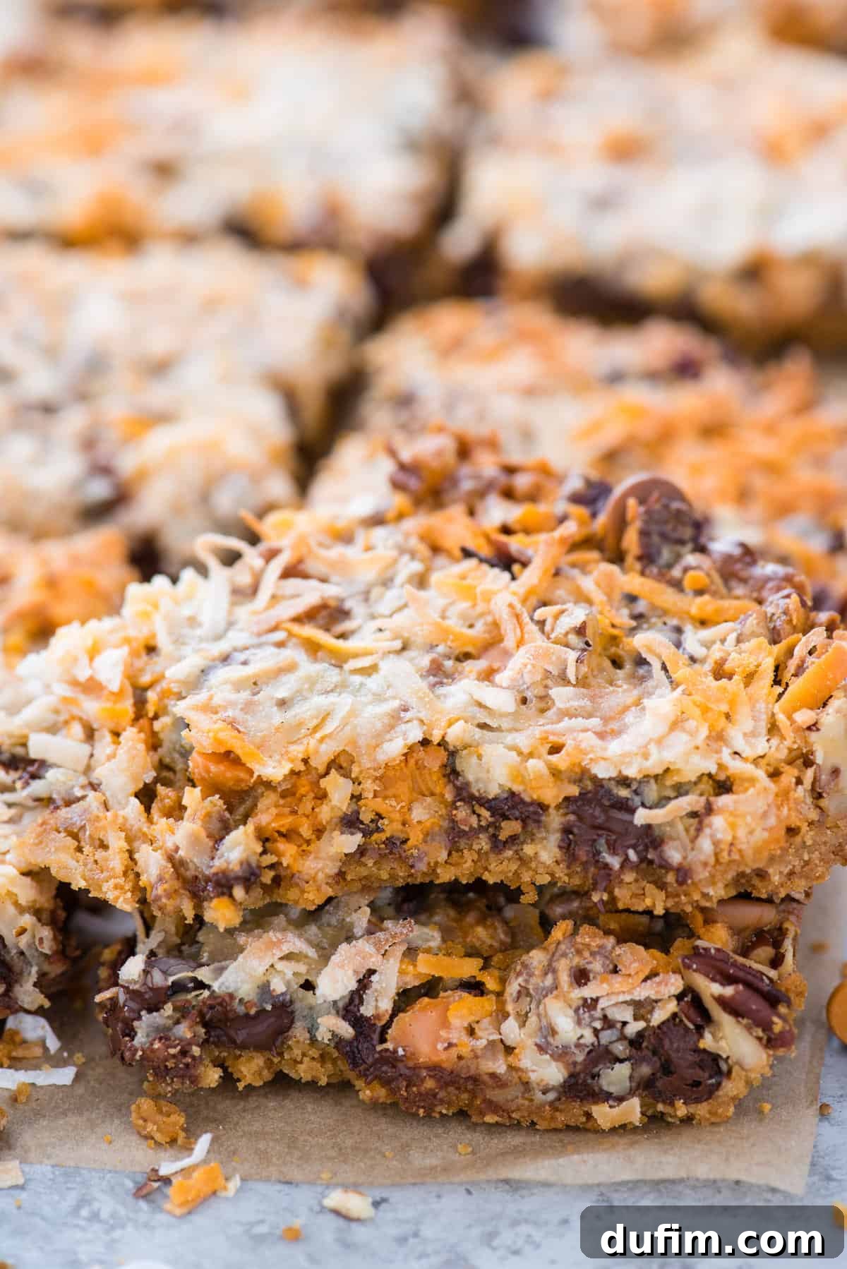 7 layer cookie bars cut into squares on brown parchment paper