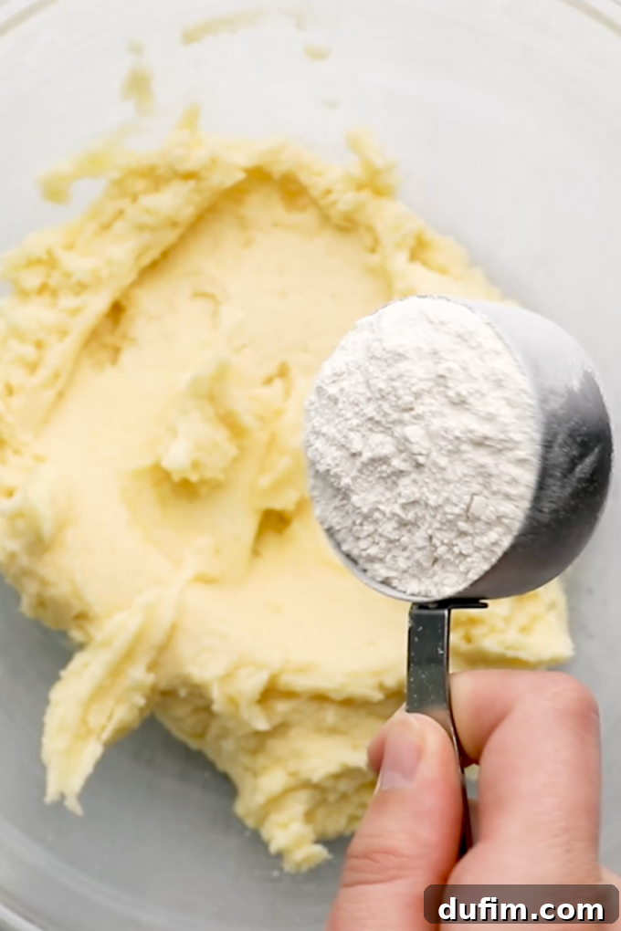 Rolling out the sugar cookie dough on parchment paper.