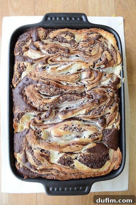 Freshly baked Earthquake Cake cooling in a 9x13 inch pan, showing the signature cracks and cream cheese swirl.