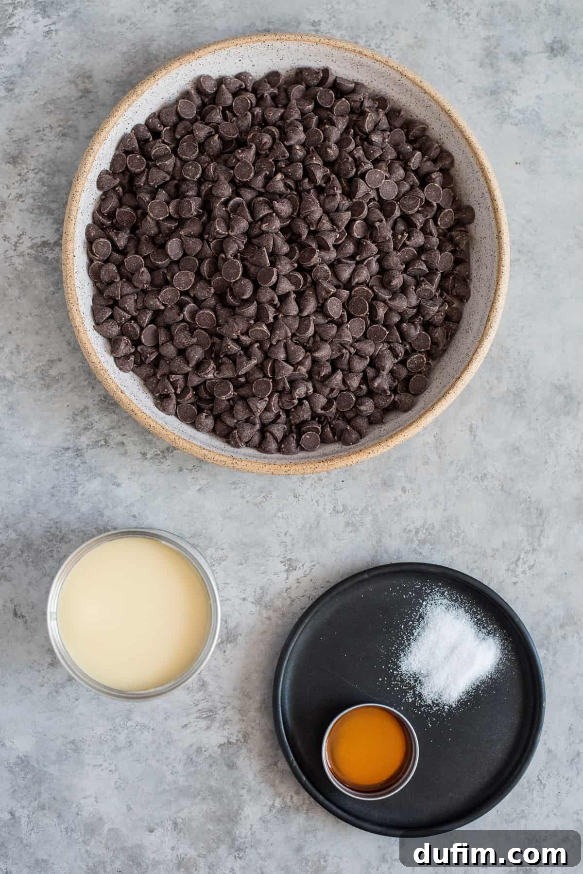 Bowls filled with the four essential ingredients for easy chocolate fudge: sweetened condensed milk, semi-sweet chocolate chips, vanilla extract, and a small pinch of salt.