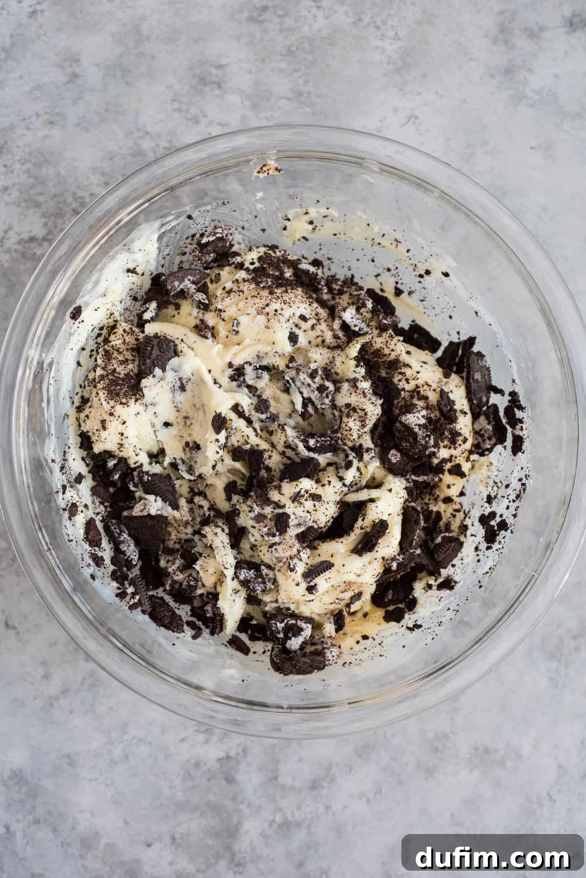 Decadent Oreo Fudge 5 Glass bowl containing the luscious white chocolate fudge base, sweetened condensed milk, and freshly chopped Oreos, ready to be spread into the pan