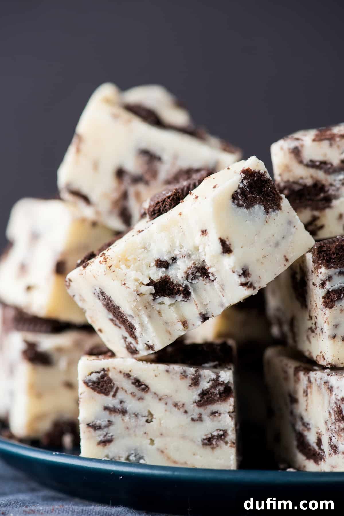 Decadent Oreo Fudge 8 Several squares of delectable Oreo fudge, stacked neatly, with the signature cookie crumbs visible, ready to be enjoyed