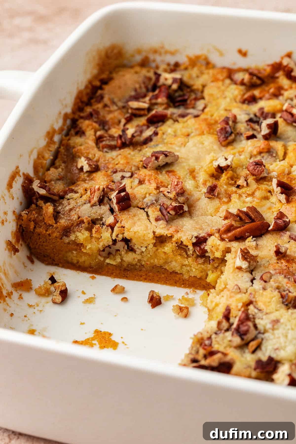 Effortless Autumn Pumpkin Dump Cake 5 A close-up shot of a scoop of pumpkin dump cake, showcasing the distinct layers of the moist pumpkin base and the golden, crunchy cake topping.