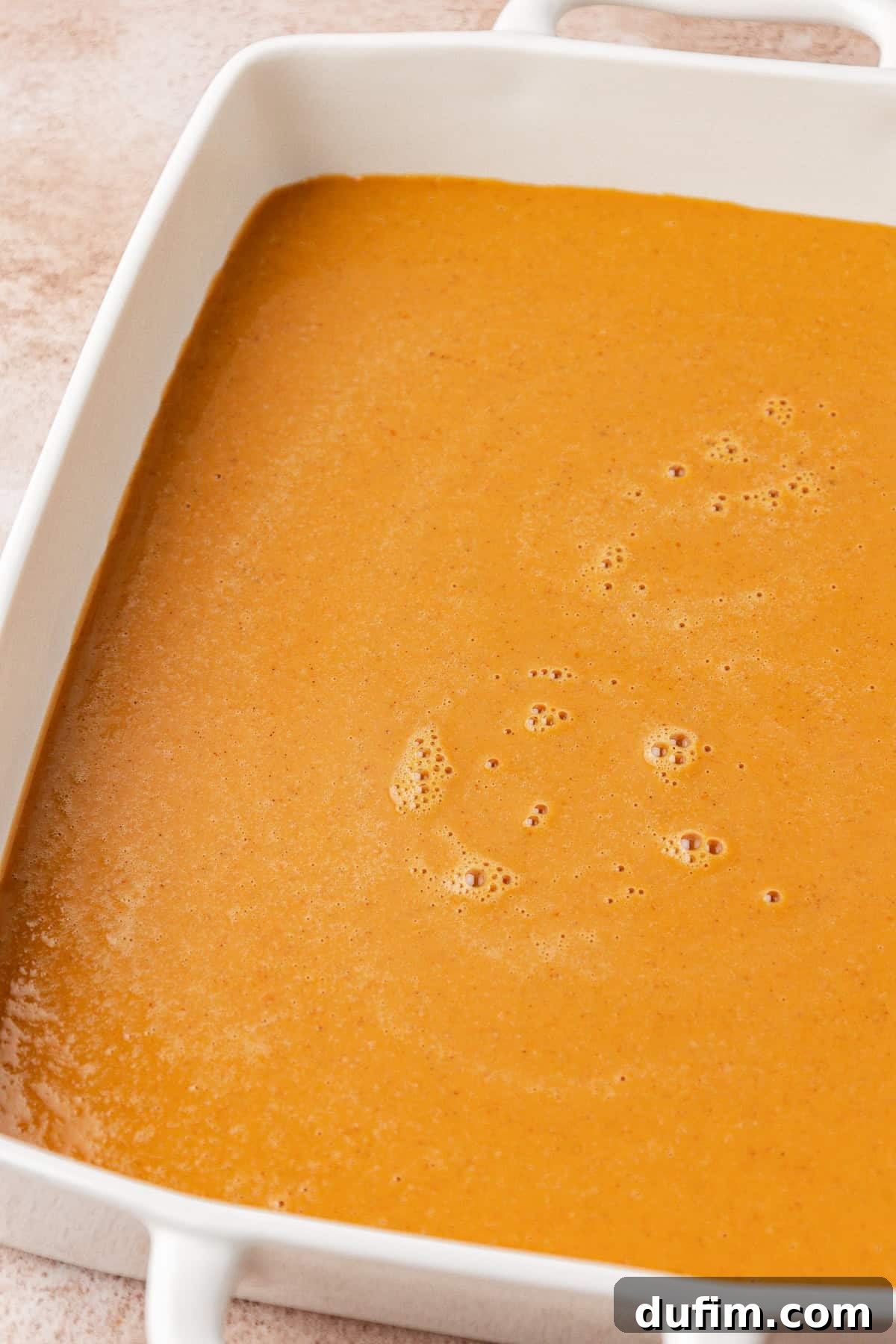 Effortless Autumn Pumpkin Dump Cake 9 Step 2: Pouring the smooth, combined pumpkin mixture evenly into the prepared 9x13 inch baking pan.
