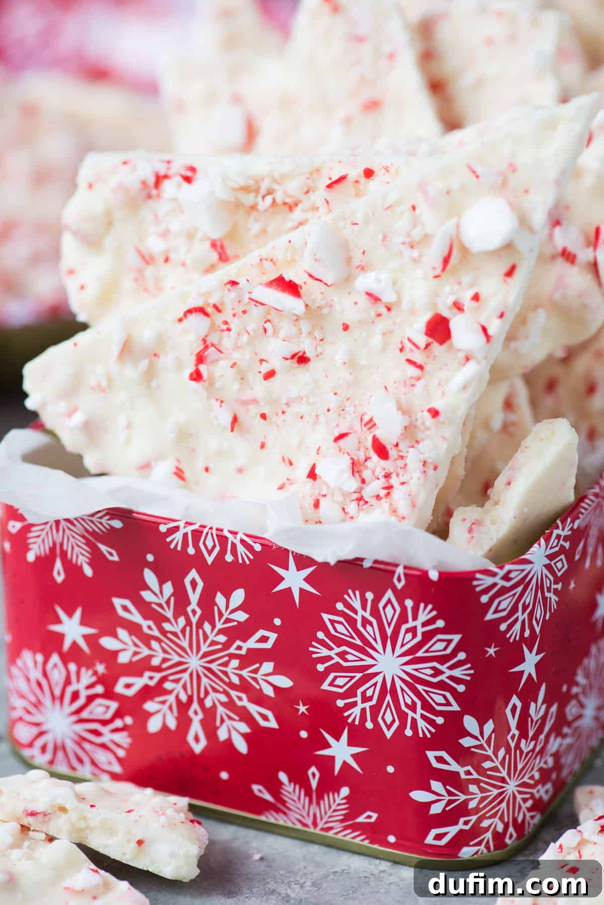 Frosted Peppermint Dream Bark 2 Red Christmas tin filled with glistening pieces of white chocolate peppermint bark and crushed candy canes.