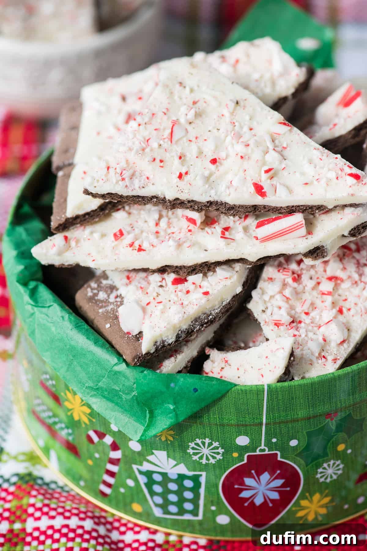 Pieces of chocolate peppermint bark nestled inside a festive Christmas cookie tin, ready for gifting or sharing