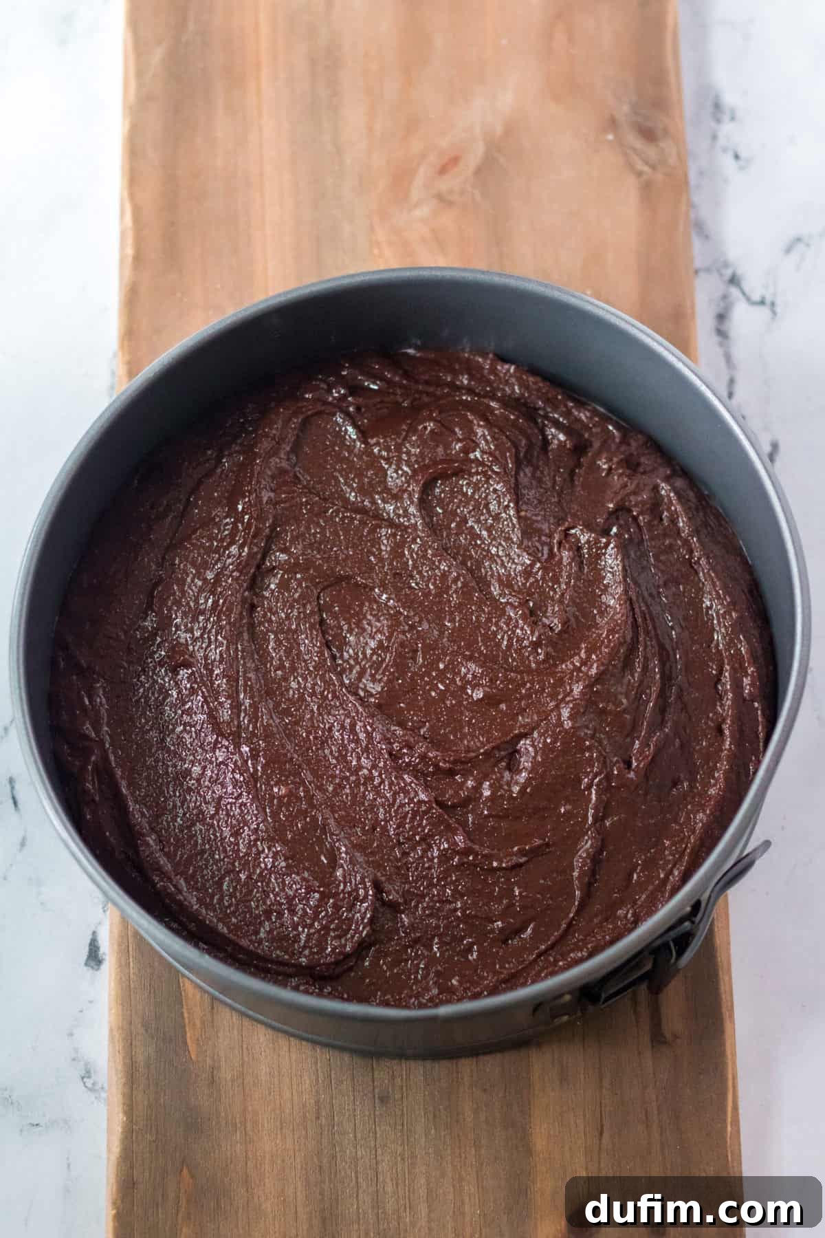 brownie batter in a circle cake pan